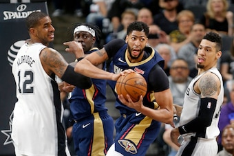 SAN ANTONIO,TX - FEBRUARY 28 : Anthony Davis #23 of the New Orleans Pelicans looks to make an outlet pass after grabbing a rebound between LaMarcus Aldridge #12 and Danny Green #14 of the San Antonio Spurs  at AT&T Center on February 28, 2018  in San Anto