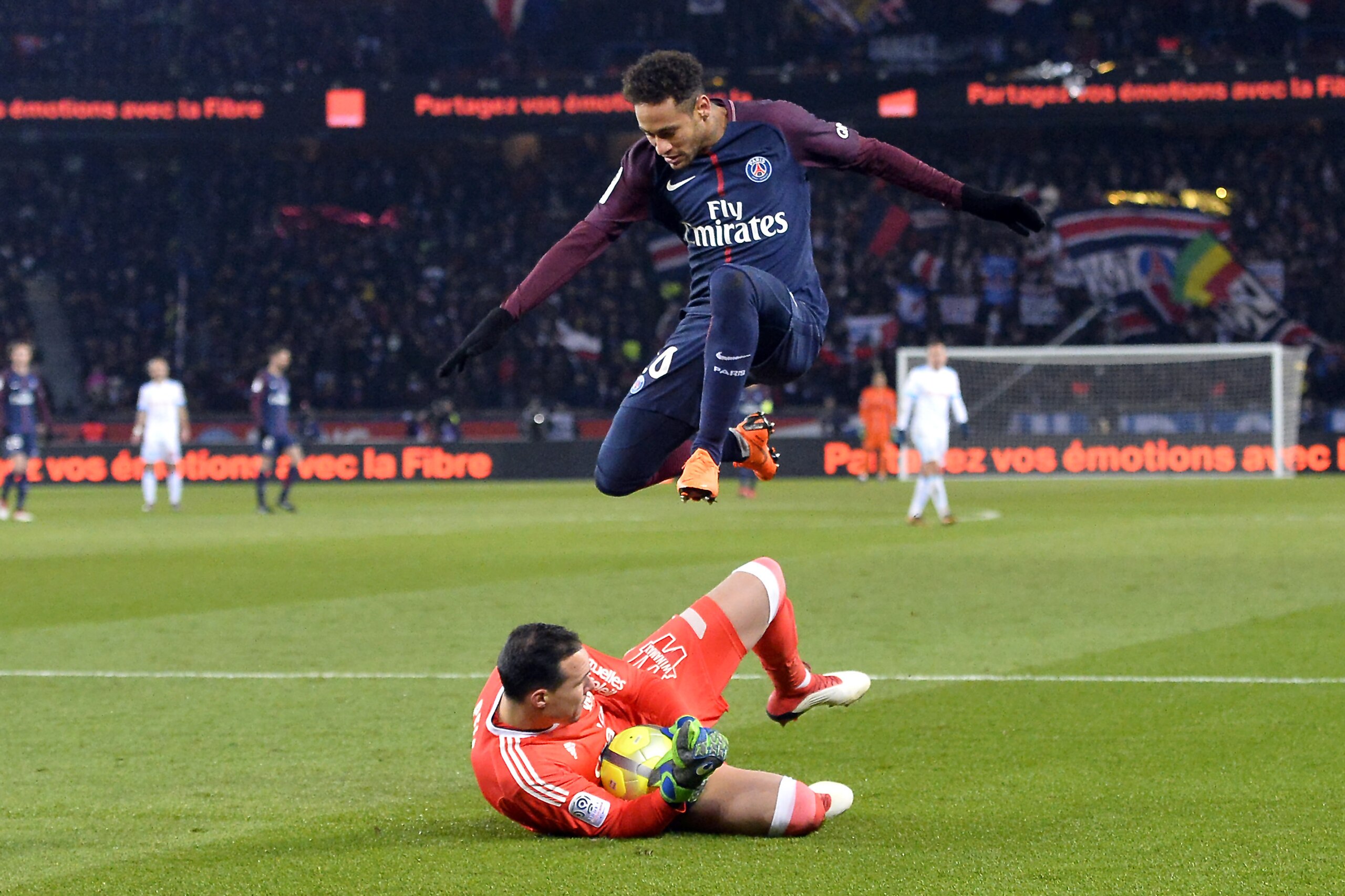 PARIS, FRANCE - FEBRUARY 25:  Neymar Jr of Paris Saint-Germain jumps over the goal keeper as he rushes to get to the ball during the Ligue 1 match between Paris Saint Germain and Olympique Marseille February 25, 2018 in Paris, France.  (Photo by Aurelien 