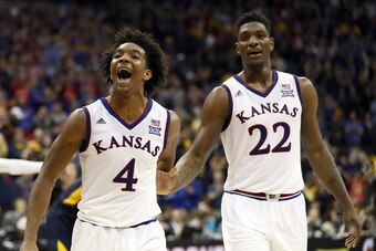 KANSAS CITY, MO - MARCH 10:  Devonte' Graham #4 of the Kansas Jayhawks celebrates with Silvio De Sousa #22 after the Jayhawks defeated the West Virginia Mountaineers 81-70 to win the Big 12 Basketball Tournament Championship game at Sprint Center on March
