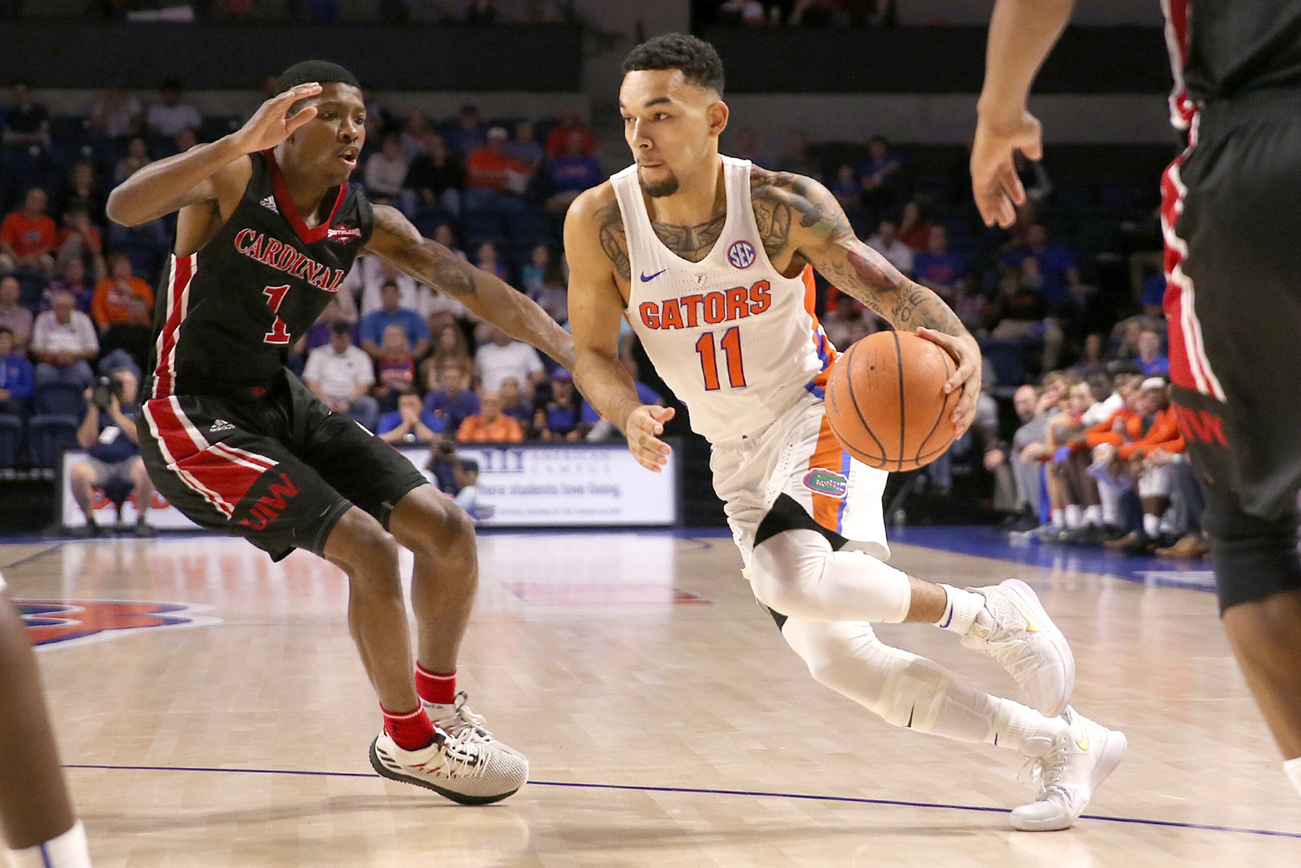 GAINESVILLE, FL - DECEMBER 22:  Chris Chiozza #11 of the Florida Gators drives past Jalin Hart #1 of the Incarnate Word Cardinals during a NCAA basketball game at the Stephen C. O' Connell Center on December 22, 2017 in Gainesville, Florida. (Photo by Ale