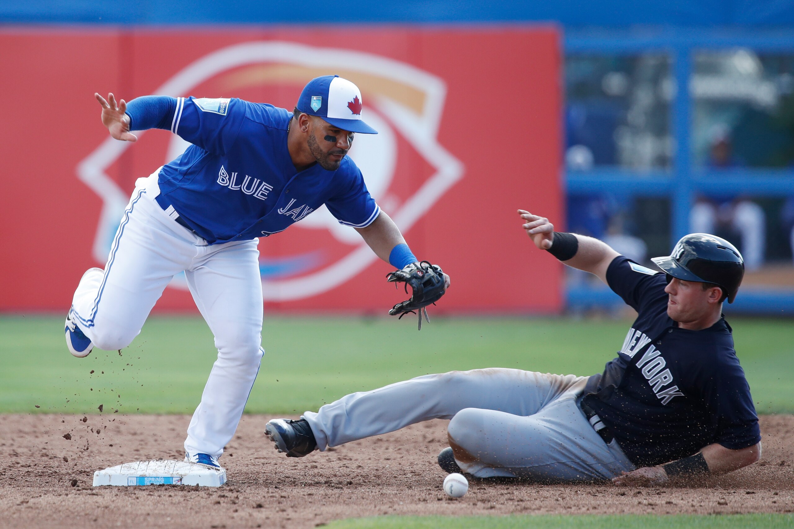 DUNEDIN, FL - FEBRUARY 27: Devon Travis #29 of the Toronto Blue Jays drops the ball while covering second base ahead of the sliding Billy McKinney #71 of the New York Yankees during a Grapefruit League spring training game at Florida Auto Exchange Stadium