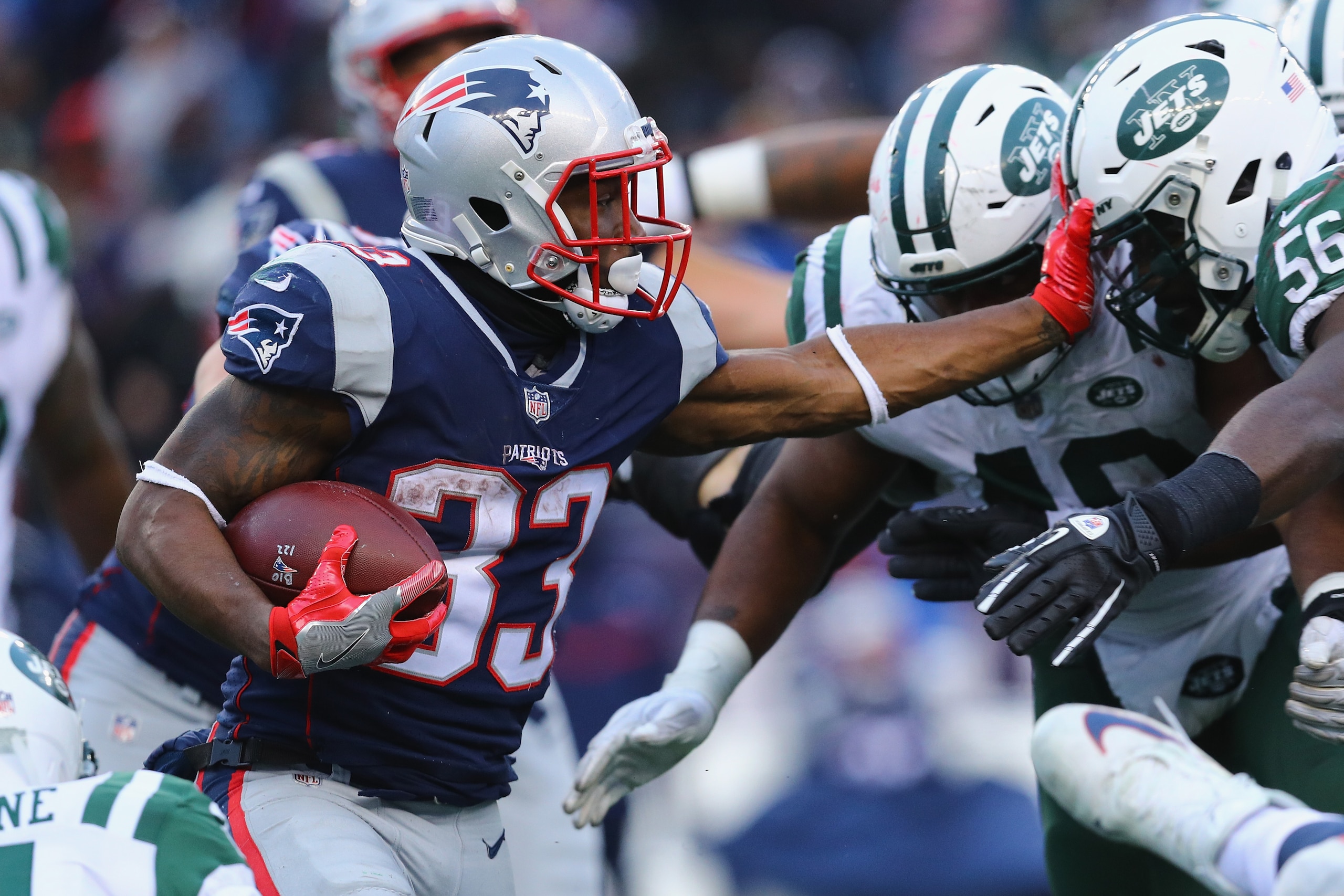 FOXBORO, MA - DECEMBER 31:  Dion Lewis #33 of the New England Patriots carries the ball against Demario Davis #56 of the New York Jets during the second half at Gillette Stadium on December 31, 2017 in Foxboro, Massachusetts.  (Photo by Maddie Meyer/Getty