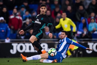BARCELONA, SPAIN - FEBRUARY 27: Marco Asensio of Real Madrid CF plays the ball past Aaron Martin of RCD Espanyol during the La Liga match between Espanyol and Real Madrid at RCDE Stadium on February 27, 2018 in Barcelona, Spain. (Photo by Alex Caparros/Ge