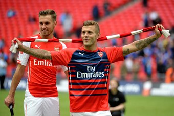 LONDON, ENGLAND - AUGUST 10: Aaron Ramsey of Arsenal and team-mate Jack Wilshere celerate after winning the FA Community Shield match between Manchester City and Arsenal at Wembley Stadium on August 10, 2014 in London, England.  (Photo by Ross Kinnaird/Ge