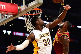 LOS ANGELES, CA - MARCH 19:  LeBron James #23 of the Cleveland Cavaliers dunks over Julius Randle #30 of the Los Angeles Lakers during the first half at Staples Center on March 19, 2017 in Los Angeles, California.  NOTE TO USER: User expressly acknowledge