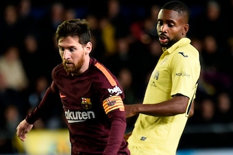 Barcelona's Argentinian forward Lionel Messi (L) vies with Villarreal's Congolese forward Cedric Bakambu during the Spanish league football match between Villarreal CF and FC Barcelona at La Ceramica stadium in Vila-real on December 10, 2017. / AFP PHOTO 