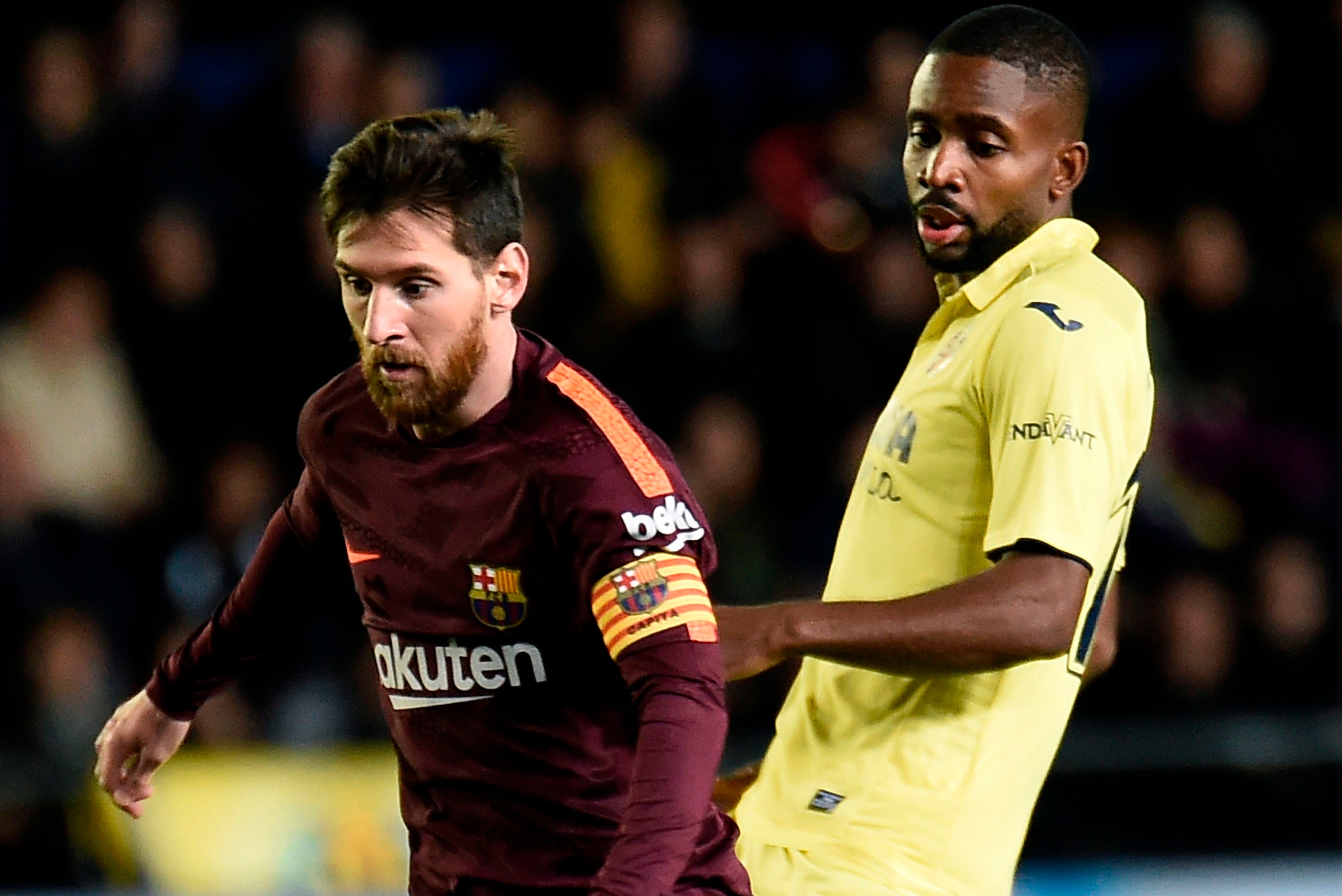 Barcelona's Argentinian forward Lionel Messi (L) vies with Villarreal's Congolese forward Cedric Bakambu during the Spanish league football match between Villarreal CF and FC Barcelona at La Ceramica stadium in Vila-real on December 10, 2017. / AFP PHOTO 