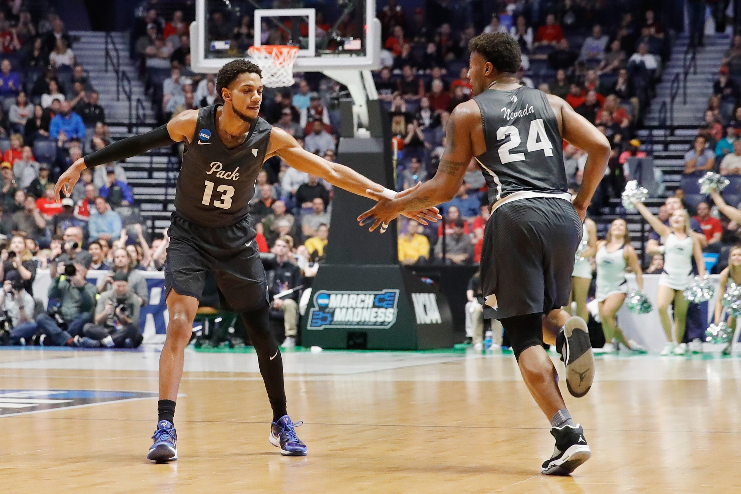 NASHVILLE, TN - MARCH 18:  Hallice Cooke #13 celebrates with Jordan Caroline #24 of the Nevada Wolf Pack against the Cincinnati Bearcats during the first half in the second round of the 2018 Men's NCAA Basketball Tournament at Bridgestone Arena on March 1
