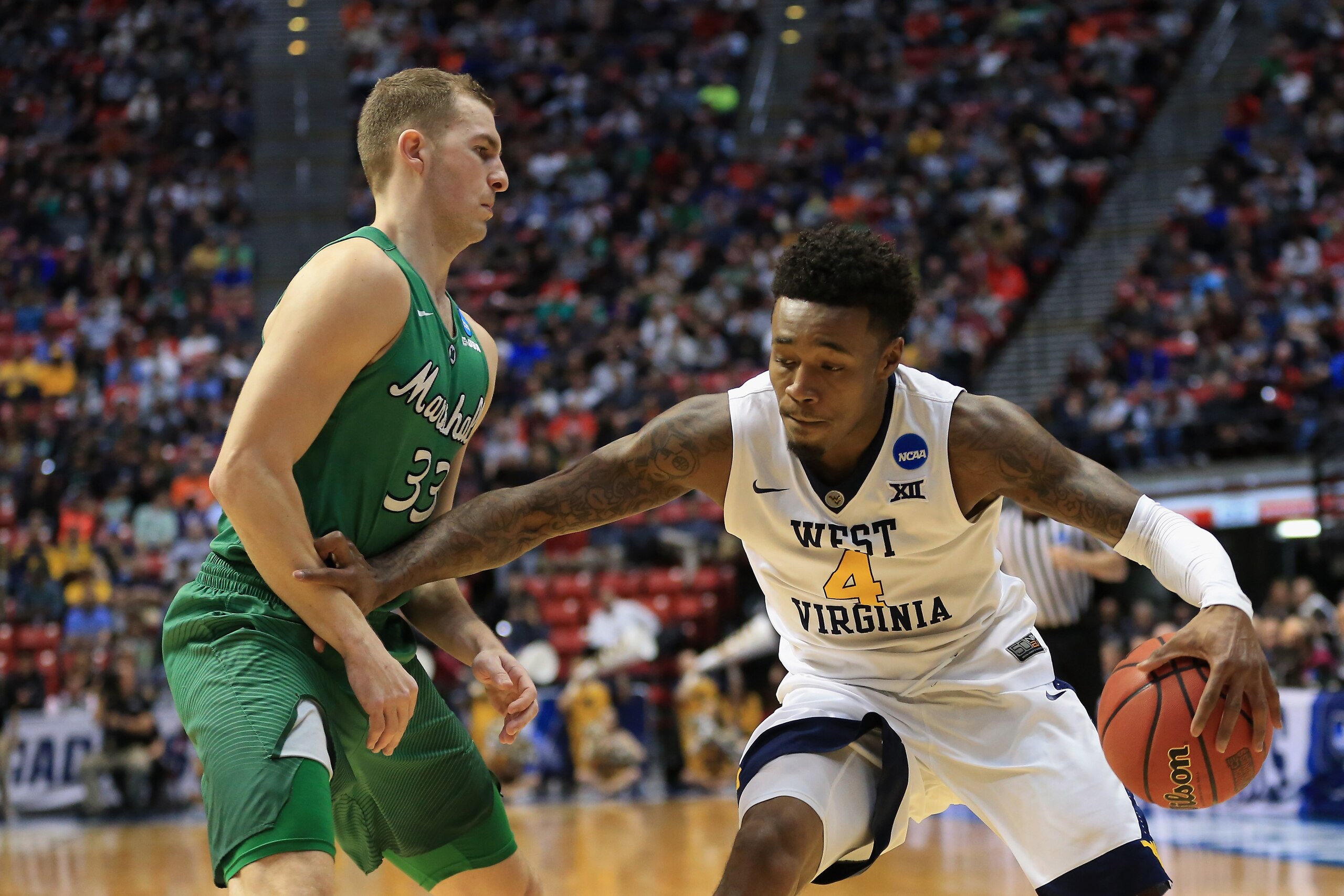 SAN DIEGO, CA - MARCH 18: Daxter Miles Jr. #4 of the West Virginia Mountaineers drives against Jon Elmore #33 of the Marshall Thundering Herd in the first half during the second round of the 2018 NCAA Men's Basketball Tournament at Viejas Arena on March 1