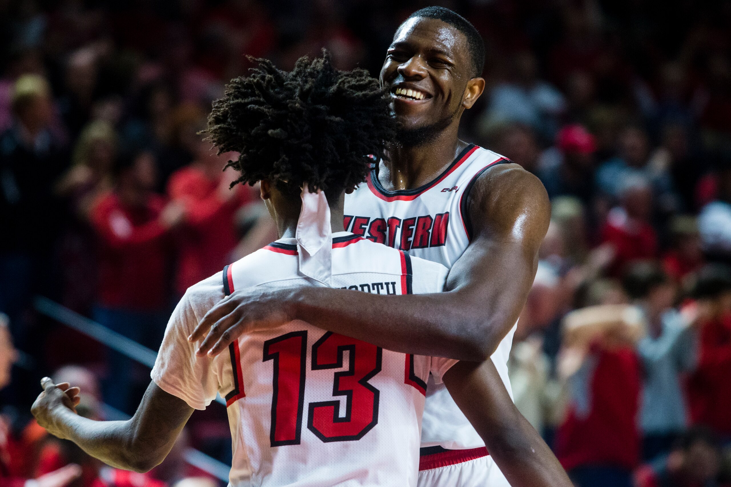 BOWLING GREEN, KY - JANUARY 27:  Forward Dwight Coleby #22 of the Western Kentucky Hilltoppers embraces  Guard Taveion Hollingsworth #13 of the Western Kentucky Hilltoppers after scoring in a game against Marshall University at E.A. Diddle Arena on Januar