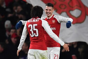 Arsenal's Swiss midfielder Granit Xhaka (R) celebrates scoring the team's second goal with Arsenal's Egyptian midfielder Mohamed Elneny during the League Cup semi-final football match between Arsenal and Chelsea at the Emirates Stadium in London on Januar
