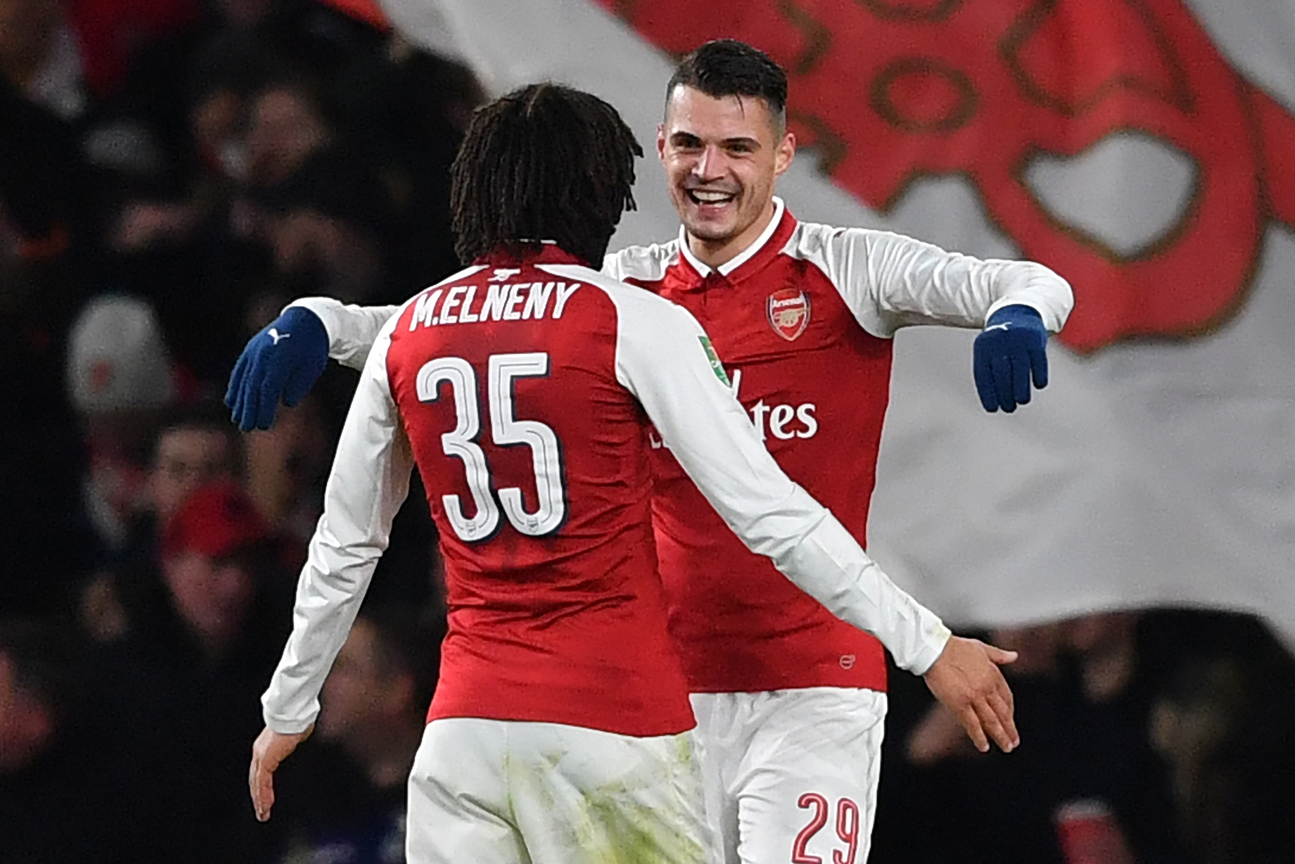 Arsenal's Swiss midfielder Granit Xhaka (R) celebrates scoring the team's second goal with Arsenal's Egyptian midfielder Mohamed Elneny during the League Cup semi-final football match between Arsenal and Chelsea at the Emirates Stadium in London on Januar