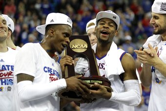 OMAHA, NE - MARCH 25: Lagerald Vick #2 and Malik Newman #14 of the Kansas Jayhawks celebrate with the regional championship trophy after defeating the Duke Blue Devils in the 2018 NCAA Men's Basketball Tournament Midwest Regional at CenturyLink Center on 