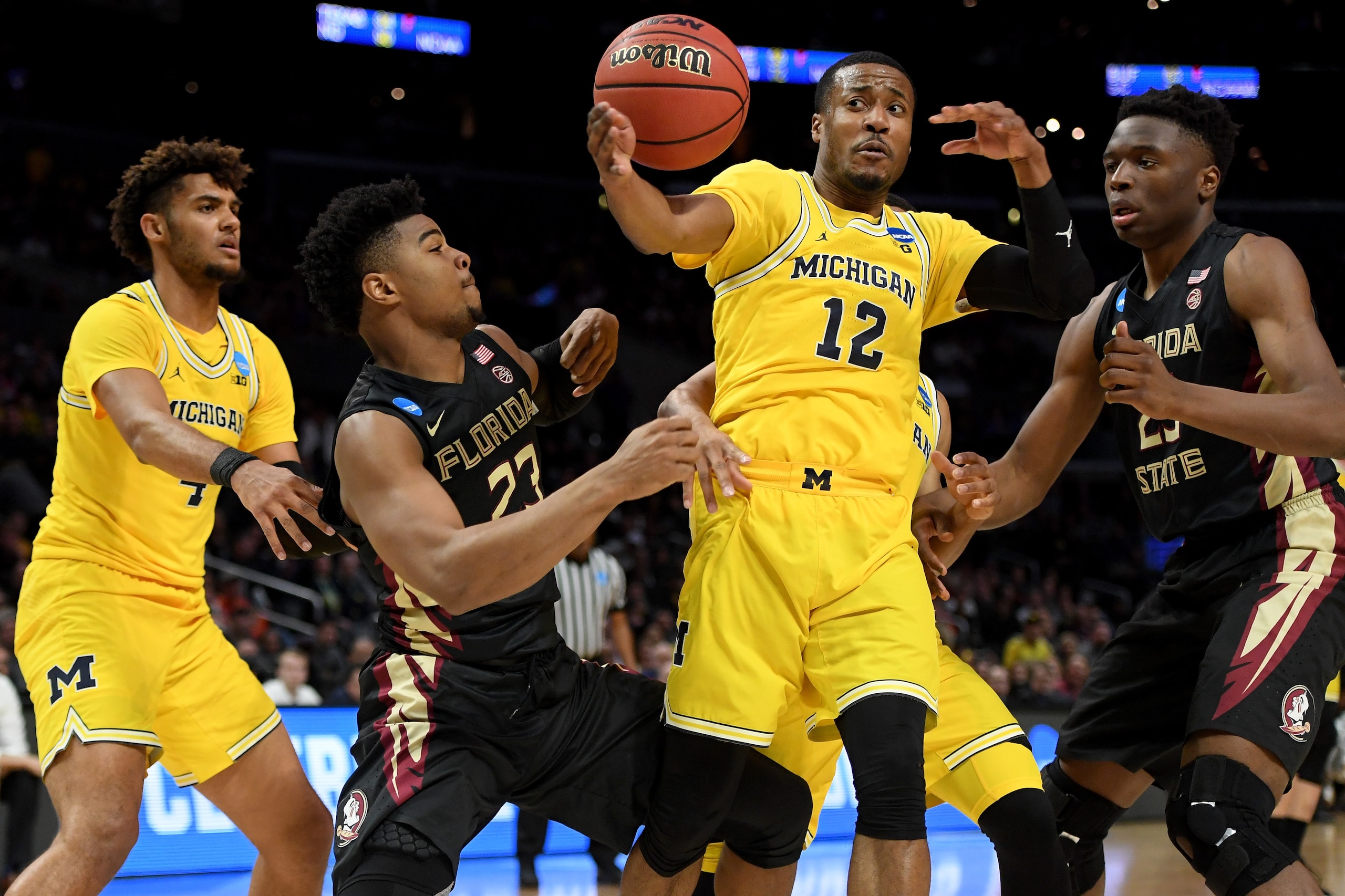 LOS ANGELES, CA - MARCH 24:  Muhammad-Ali Abdur-Rahkman #12 of the Michigan Wolverines goes after the ball between M.J. Walker #23 and Mfiondu Kabengele #25 of the Florida State Seminoles in the first half in the 2018 NCAA Men's Basketball Tournament West