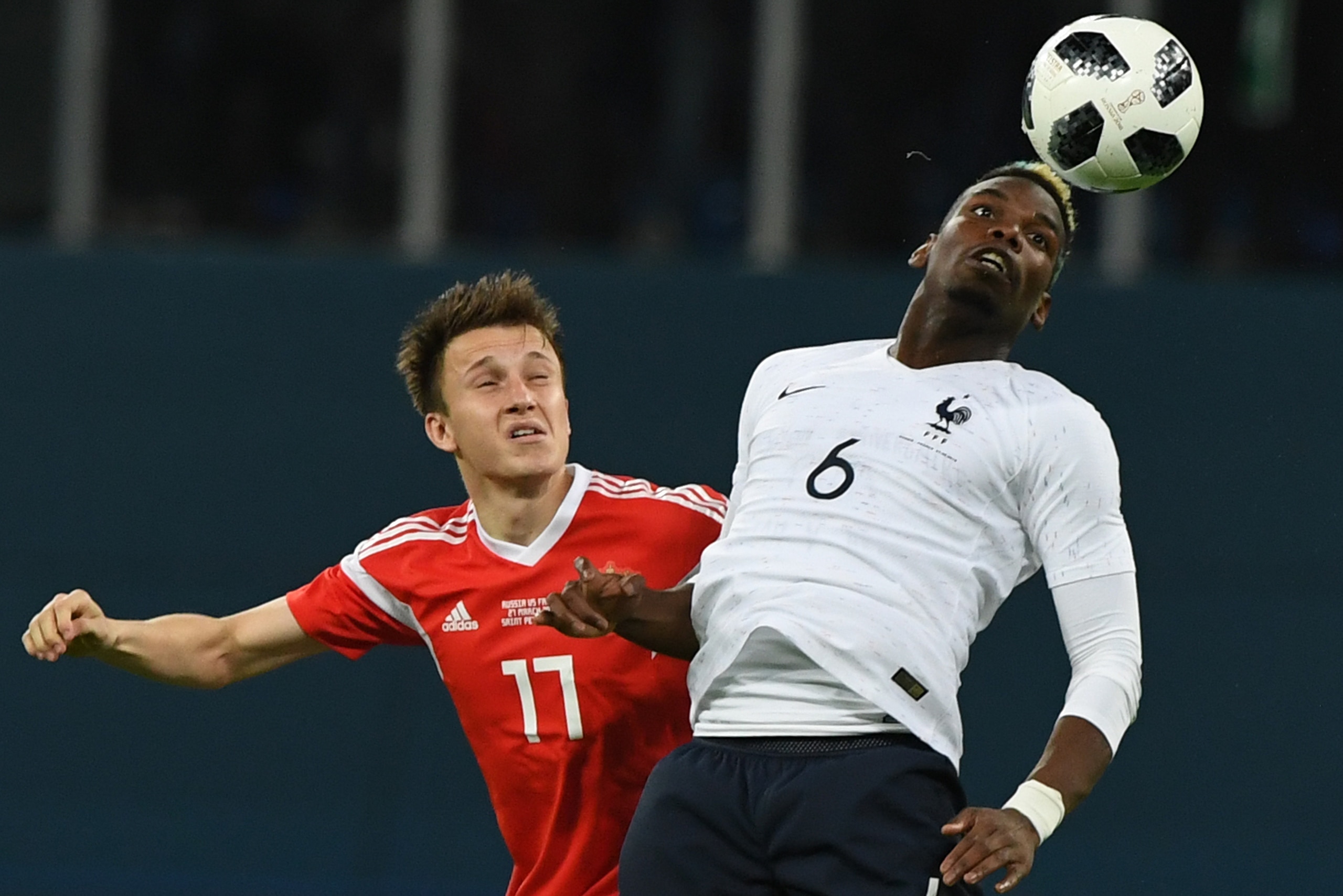 Russia's midfielder Alexander Golovin (L) and France's midfielder Paul Pogba vie for the ball during an international friendly football match between Russia and France at the Saint Petersburg Stadium in Saint Petersburg on March 27, 2018. / AFP PHOTO / Ki
