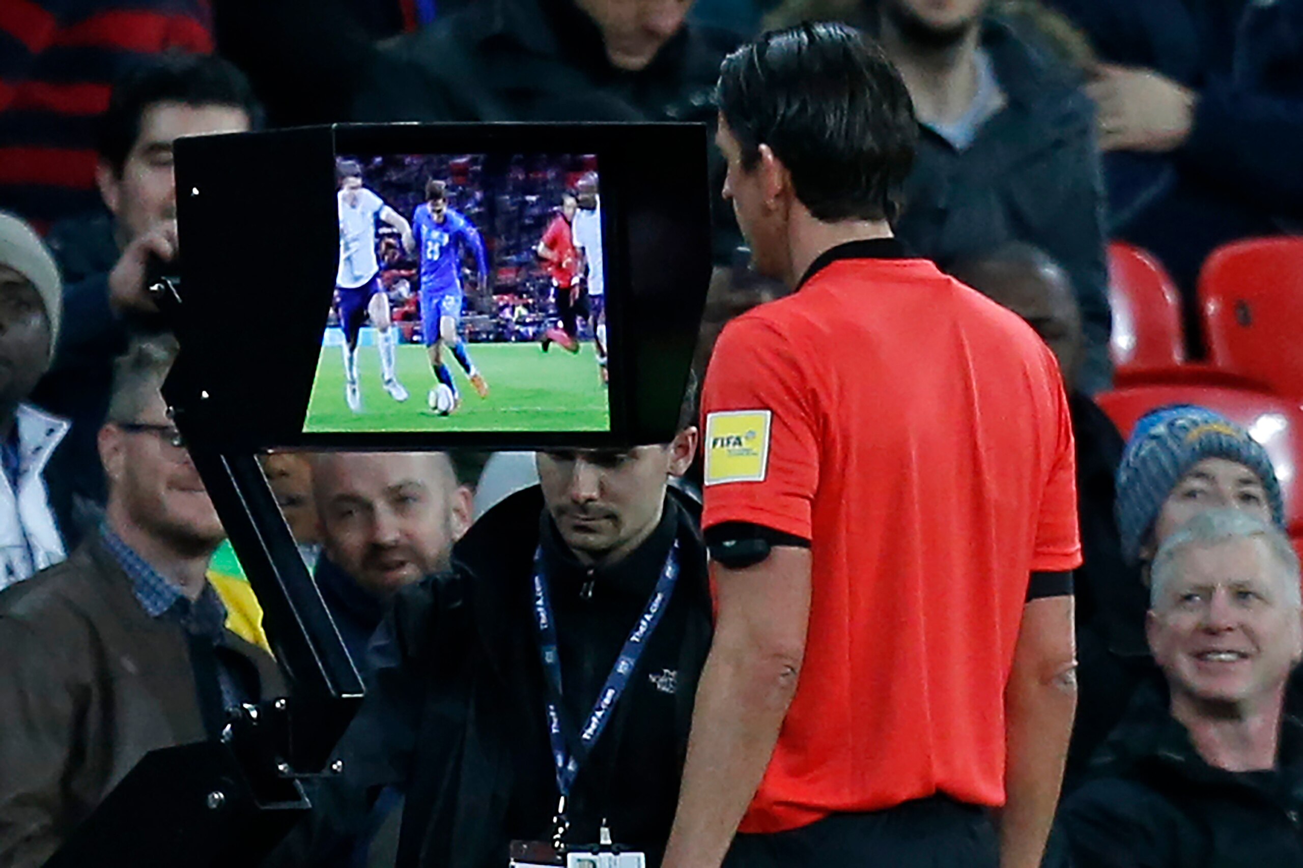 German referee Deniz Aytekin studies the VAR (Video Assistant Referee) screen to see if Italy deserve a penalty during the International friendly football match between England and Italy at Wembley stadium in London on March 27, 2018. / AFP PHOTO / Ian KI
