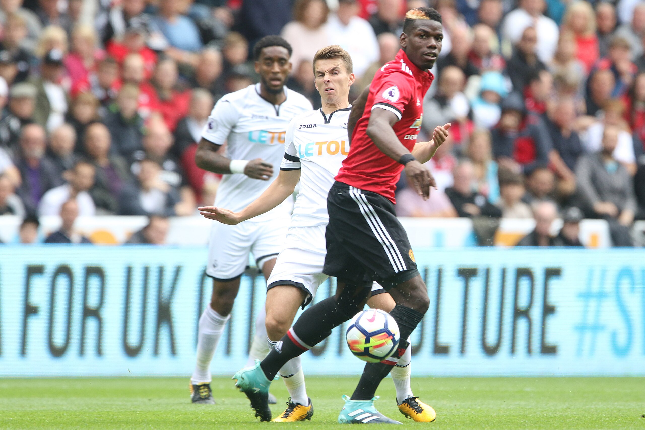 SWANSEA, WALES - AUGUST 19: Tom Carroll of Swansea City watches the ball as he is marked by Paul Pogba of Manchester United during the Premier League match between Swansea City and Manchester United at The Liberty Stadium on August 19, 2017 in Swansea, Wa SWANSEA, WALES - AUGUST 19: Tom Carroll of Swansea City watches the ball as he is marked by Paul Pogba of Manchester United during the Premier League match between Swansea City and Manchester United at The Liberty Stadium on August 19, 2017 in Swansea, Wa
