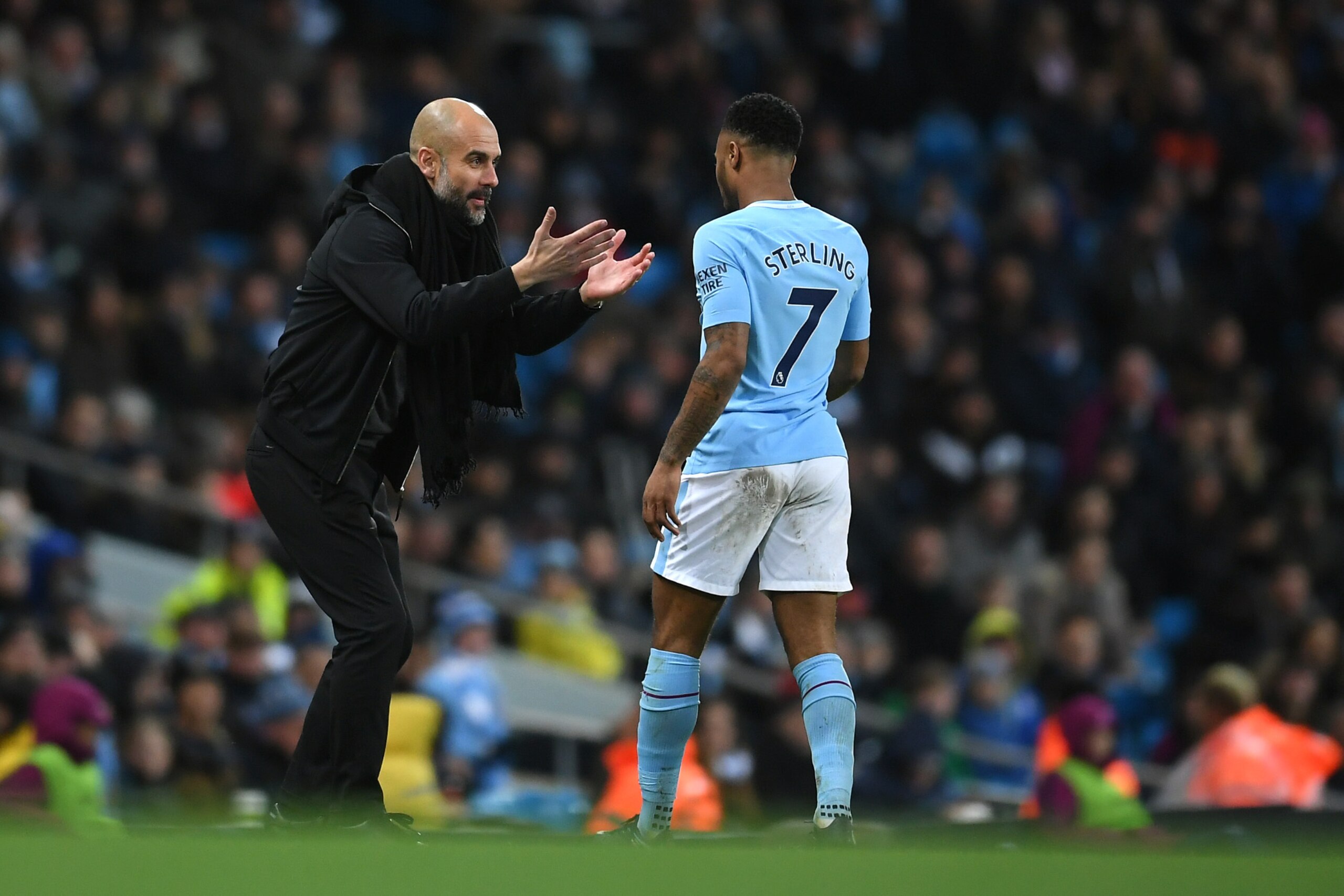 MANCHESTER, ENGLAND - JANUARY 31:  Josep Guardiola, Manager of Manchester City looks to embrace Raheem Sterling of Manchester City during the Premier League match between Manchester City and West Bromwich Albion at Etihad Stadium on January 31, 2018 in Ma