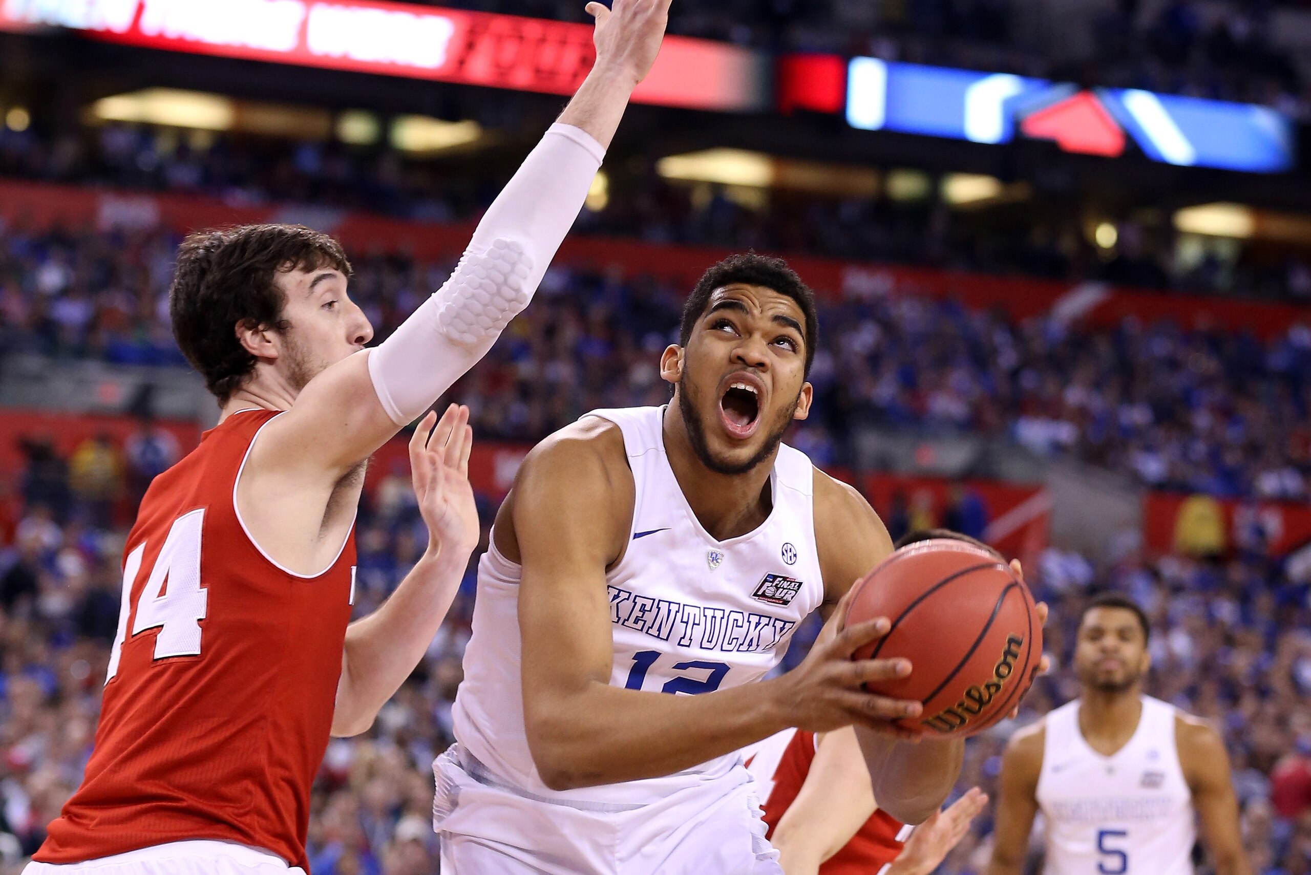 INDIANAPOLIS, IN - APRIL 04: Karl-Anthony Towns #12 of the Kentucky Wildcats handles the ball against Frank Kaminsky #44 of the Wisconsin Badgers in the first half during the NCAA Men's Final Four Semifinal at Lucas Oil Stadium on April 4, 2015 in Indiana