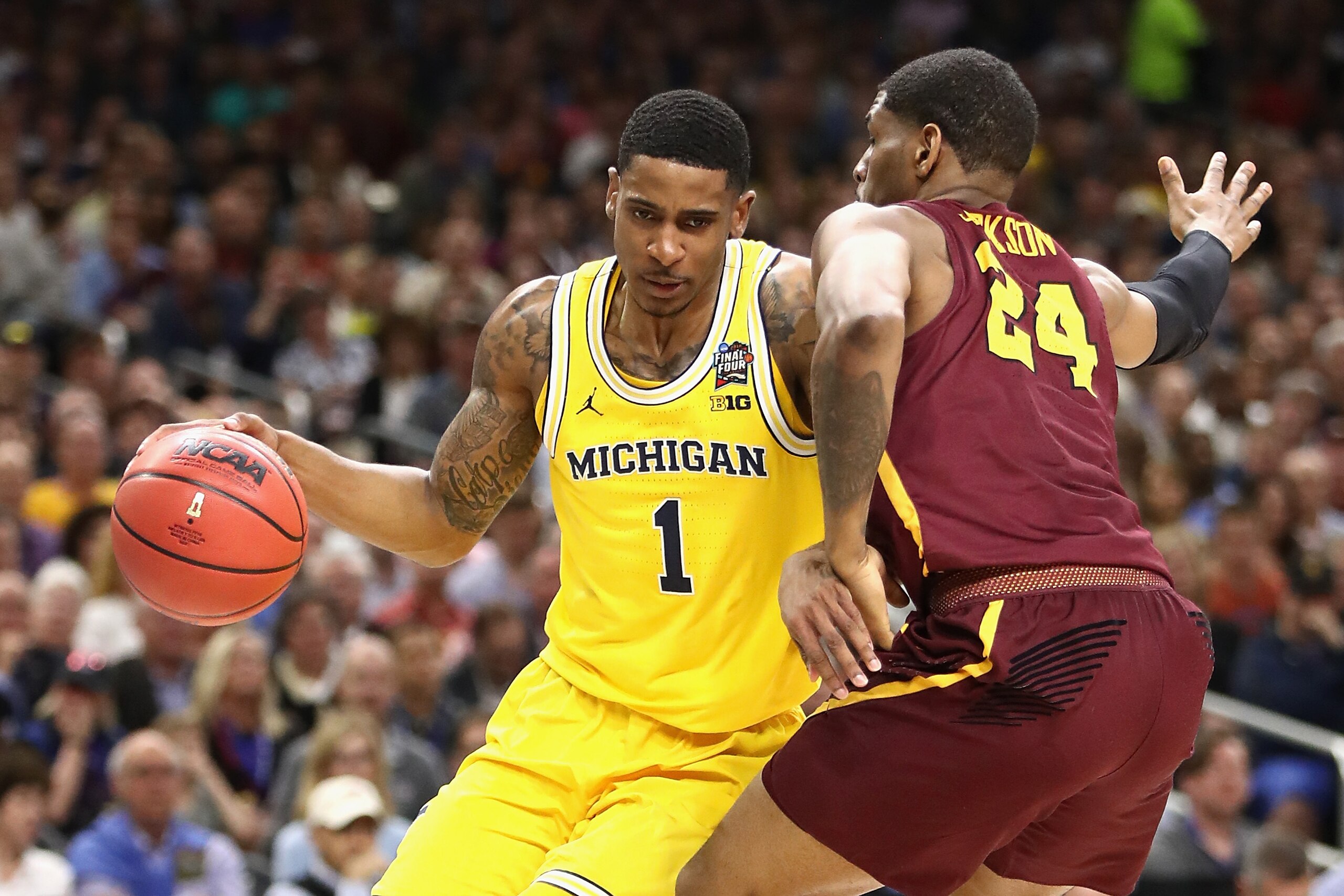 SAN ANTONIO, TX - MARCH 31: Charles Matthews #1 of the Michigan Wolverines handles the ball against Aundre Jackson #24 of the Loyola Ramblers in the first half during the 2018 NCAA Men's Final Four Semifinal at the Alamodome on March 31, 2018 in San Anton