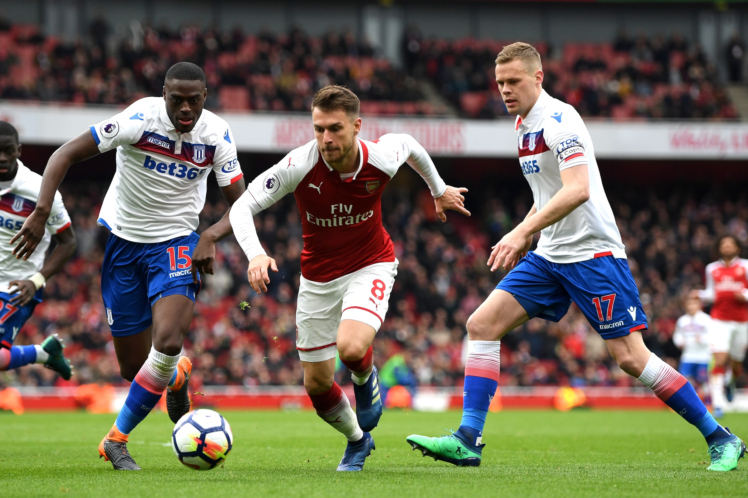 LONDON, ENGLAND - APRIL 01: Aaron Ramsey of Arsenal gets away from Bruno Martins Indi of Stoke City and Ryan Shawcross of Stoke City during the Premier League match between Arsenal and Stoke City at Emirates Stadium on April 1, 2018 in London, England.  (