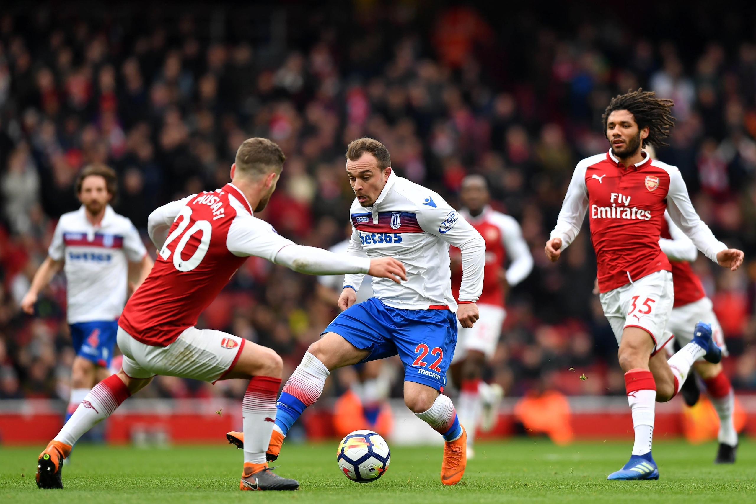 Stoke City's Swiss forward Xherdan Shaqiri (C) vies with Arsenal's German defender Shkodran Mustafi (L) during the English Premier League football match between Arsenal and Stoke City at the Emirates Stadium in London on April 1, 2018.  / AFP PHOTO / Oliv