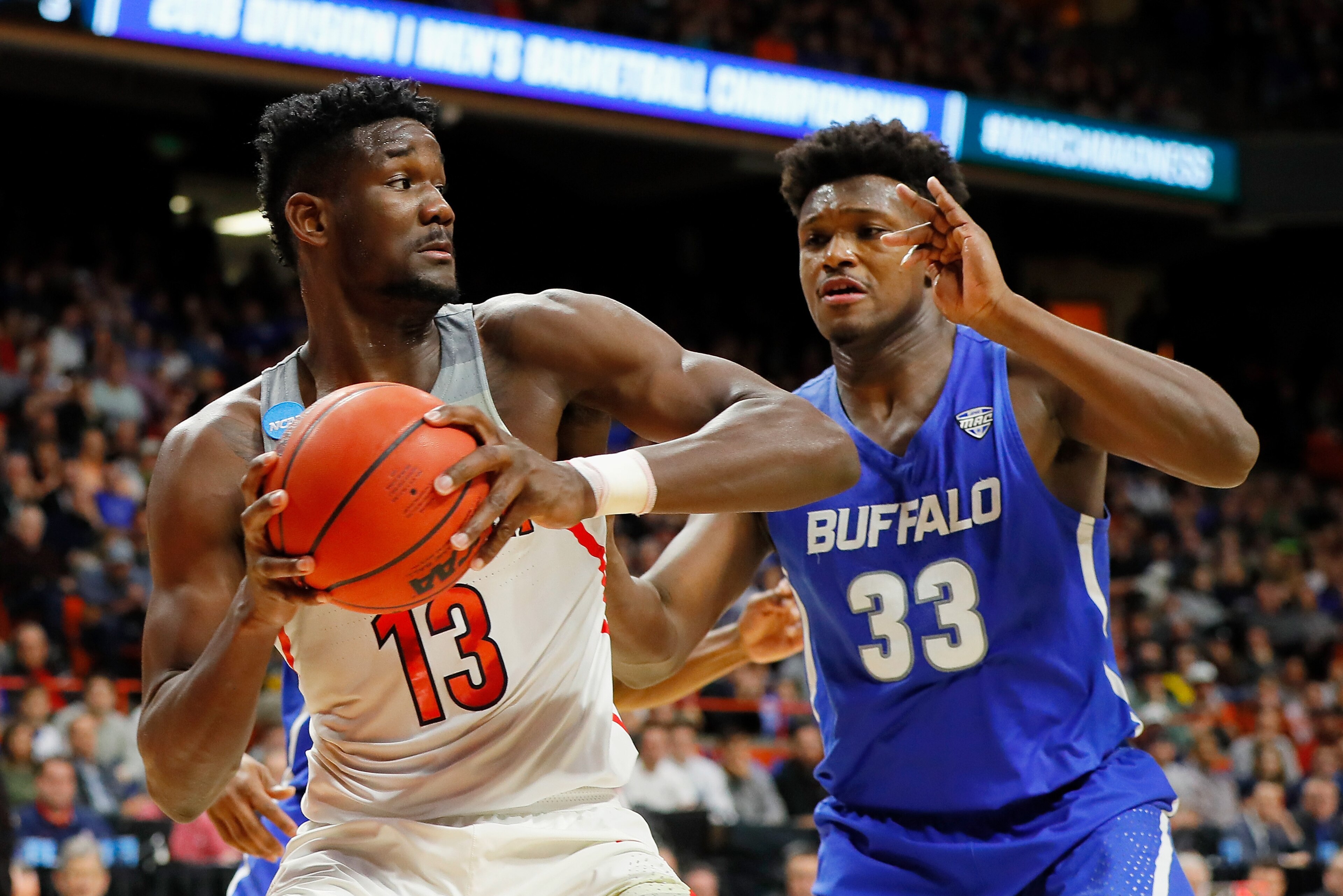 BOISE, ID - MARCH 15: Deandre Ayton #13 of the Arizona Wildcats handles the ball against Nick Perkins #33 of the Buffalo Bulls in the second half during the first round of the 2018 NCAA Men's Basketball Tournament at Taco Bell Arena on March 15, 2018 in BOISE, ID - MARCH 15: Deandre Ayton #13 of the Arizona Wildcats handles the ball against Nick Perkins #33 of the Buffalo Bulls in the second half during the first round of the 2018 NCAA Men's Basketball Tournament at Taco Bell Arena on March 15, 2018 in