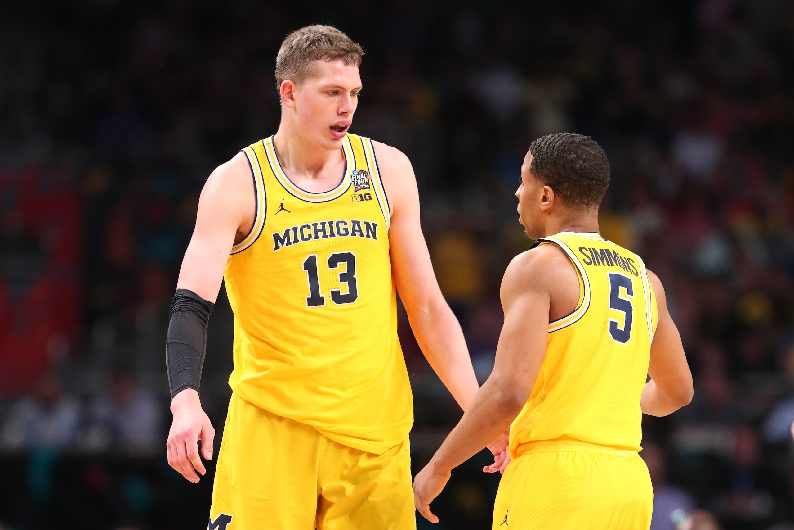 SAN ANTONIO, TX - MARCH 31:  Moritz Wagner #13 and Jaaron Simmons #5 of the Michigan Wolverines discuss the play against the Loyola Ramblers in the first half during the 2018 NCAA Men's Final Four Semifinal at the Alamodome on March 31, 2018 in San Antoni
