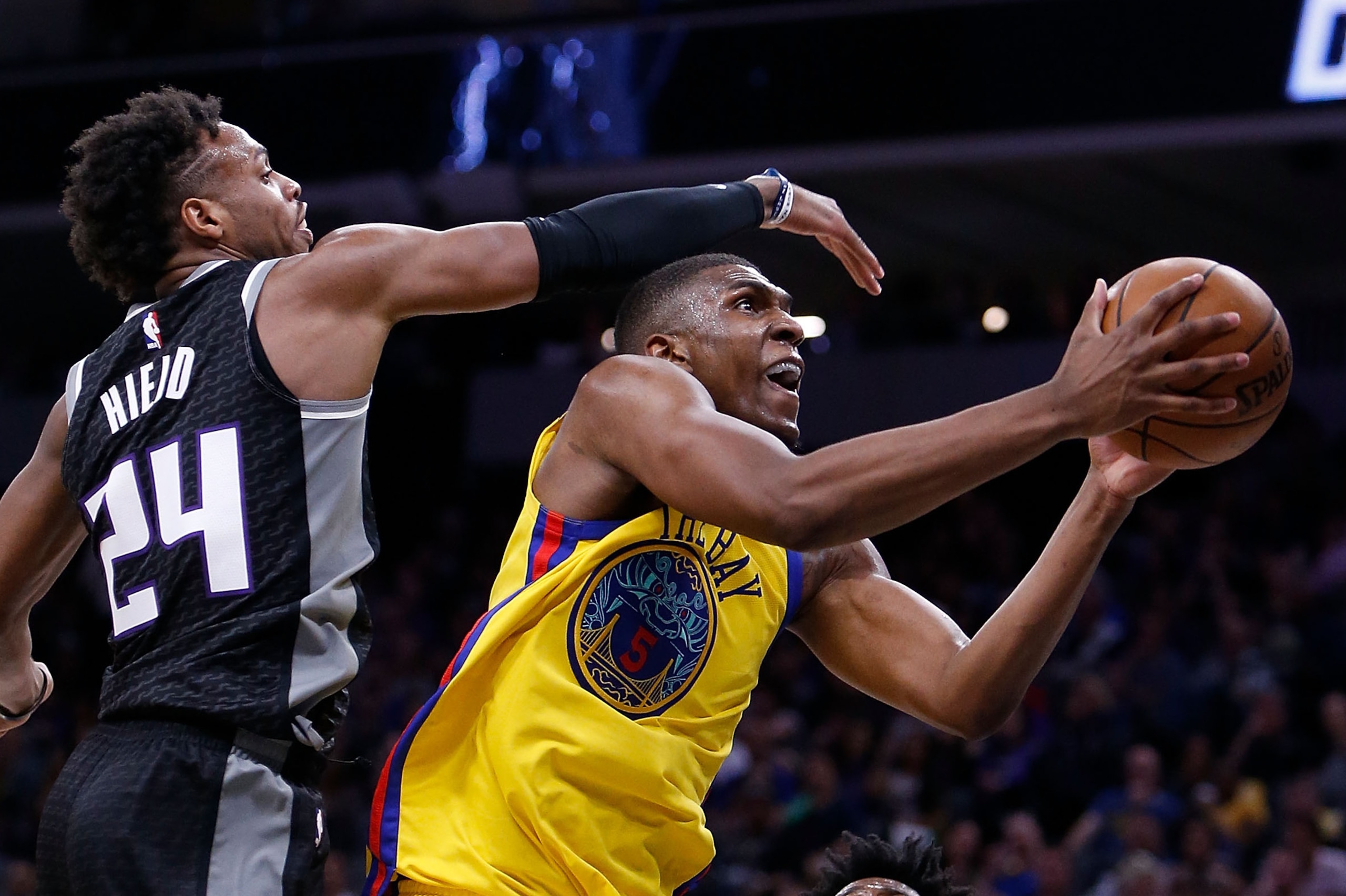 SACRAMENTO, CA - MARCH 31: Kevon Looney #5 of the Golden State Warriors goes to the basket against Buddy Hield #24 of the Sacramento Kings at Golden 1 Center on March 31, 2018 in Sacramento, California. NOTE TO USER: User expressly acknowledges and agrees