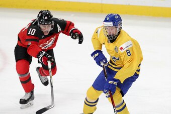 BUFFALO, NY - JANUARY 05: Rasmus Dahlin #8 of Sweden skates the puck past Kale Clague #10 of Canada during the second  period of play in the IIHF World Junior Championships Gold Medal game at KeyBank Center on January 5, 2018 in Buffalo, New York. (Photo 