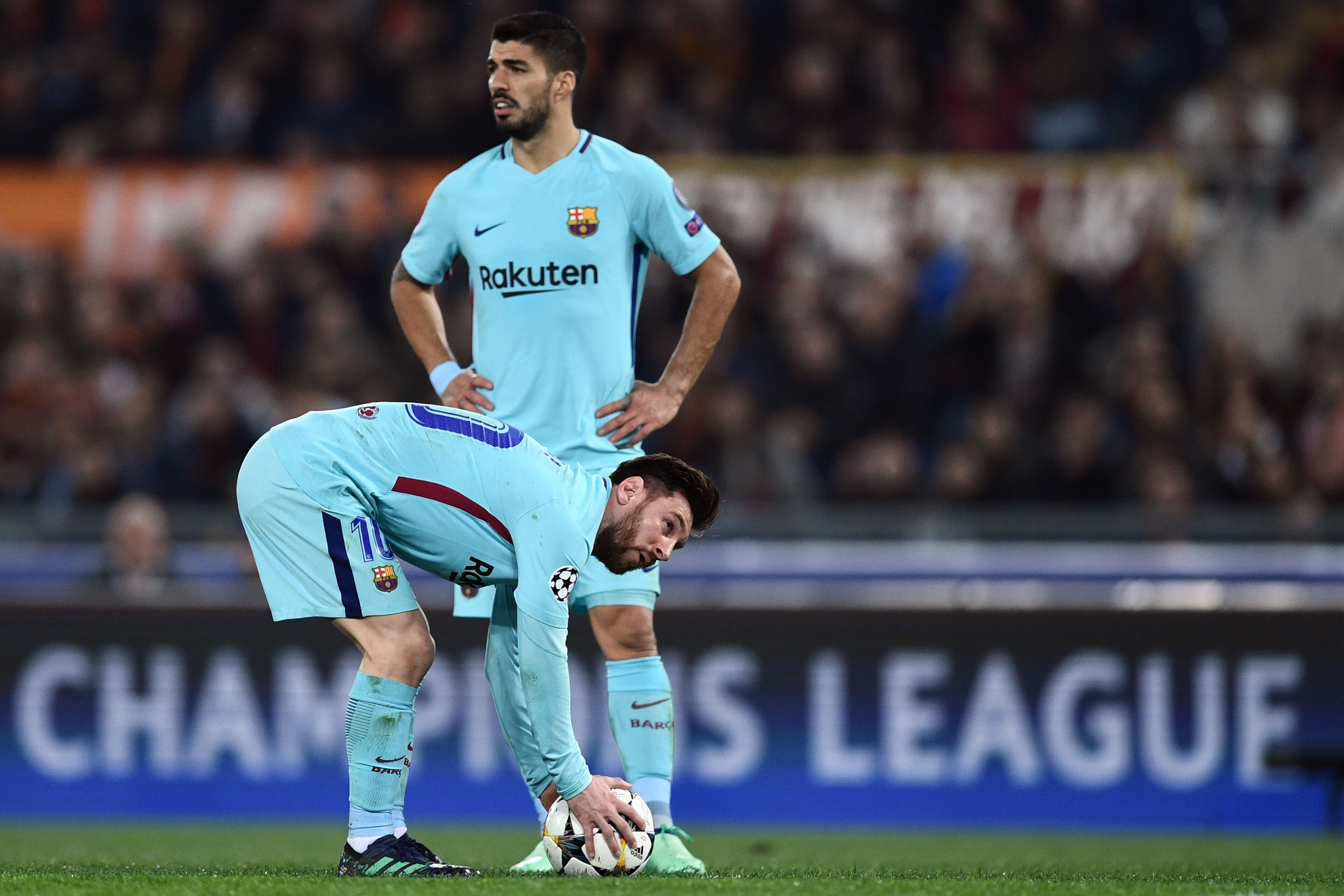 FC Barcelona's Argentinian forward Lionel Messi (down) gets ready for a free kick next to FC Barcelona's Spanish midfielder Denis Suarez during the UEFA Champions League quarter-final second leg football match between AS Roma and FC Barcelona at the Olymp
