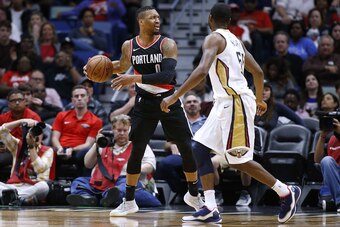 NEW ORLEANS, LA - MARCH 27: Damian Lillard #0 of the Portland Trail Blazers drives against E'Twaun Moore #55 of the New Orleans Pelicans during the first half at the Smoothie King Center on March 27, 2018 in New Orleans, Louisiana. NOTE TO USER: User expr