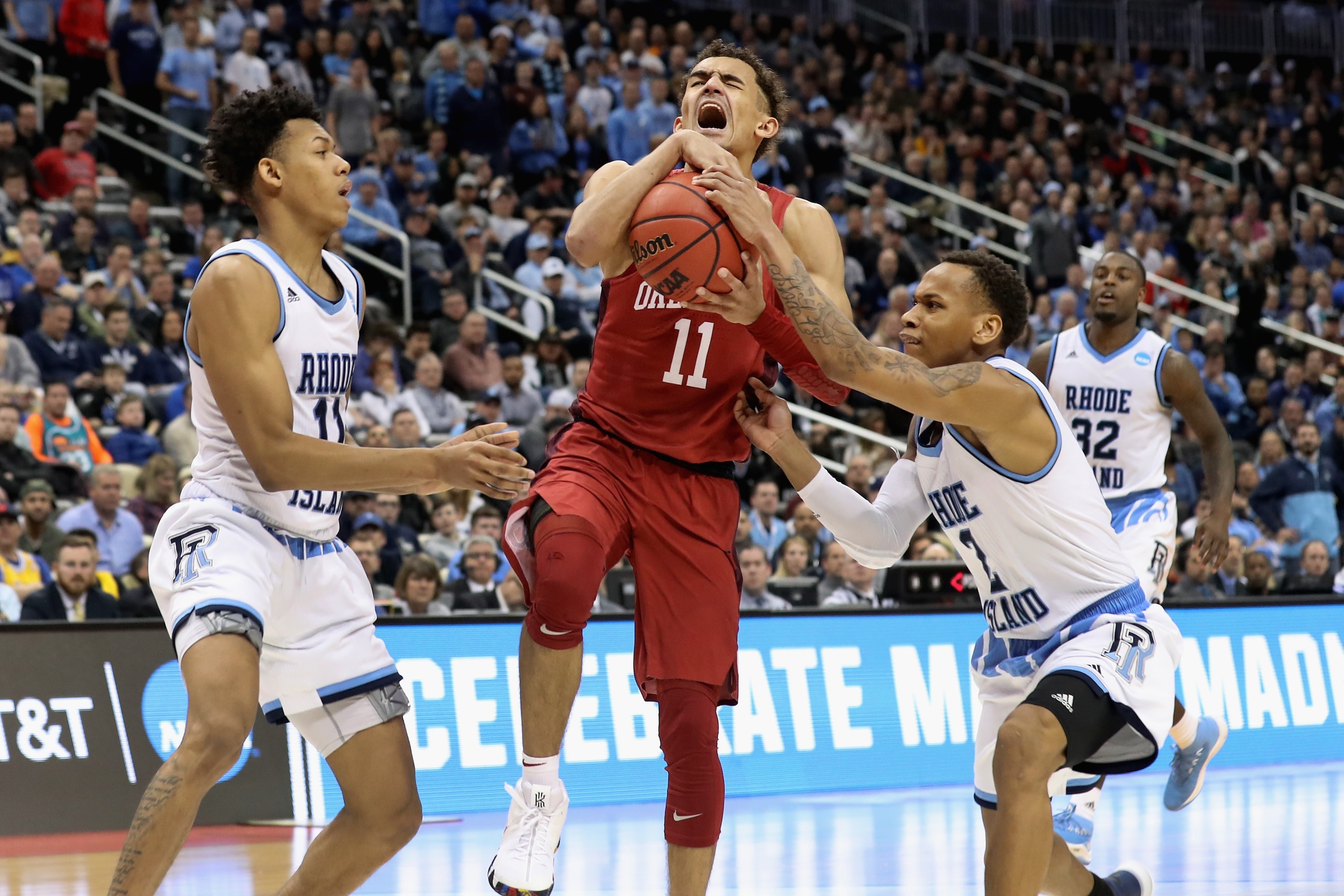 PITTSBURGH, PA - MARCH 15:  Trae Young #11 of the Oklahoma Sooners reacts between Jeff Dowtin #11 and Fatts Russell #2 of the Rhode Island Rams in the second half of the game during the first round of the 2018 NCAA Men's Basketball Tournament at PPG PAINT
