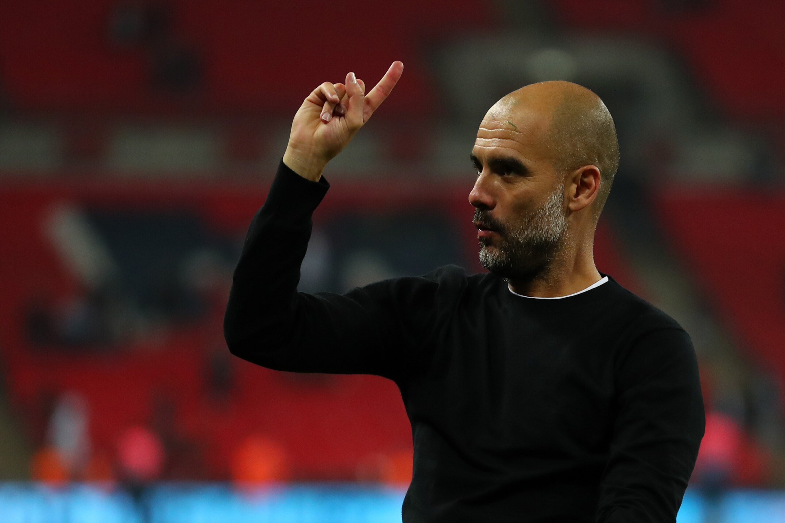 LONDON, ENGLAND - APRIL 14: Pep Guardiola the head coach / manager of Manchester City raises his finger to indicate one more game after the Premier League match between Tottenham Hotspur and Manchester City at Wembley Stadium on April 14, 2018 in London, 