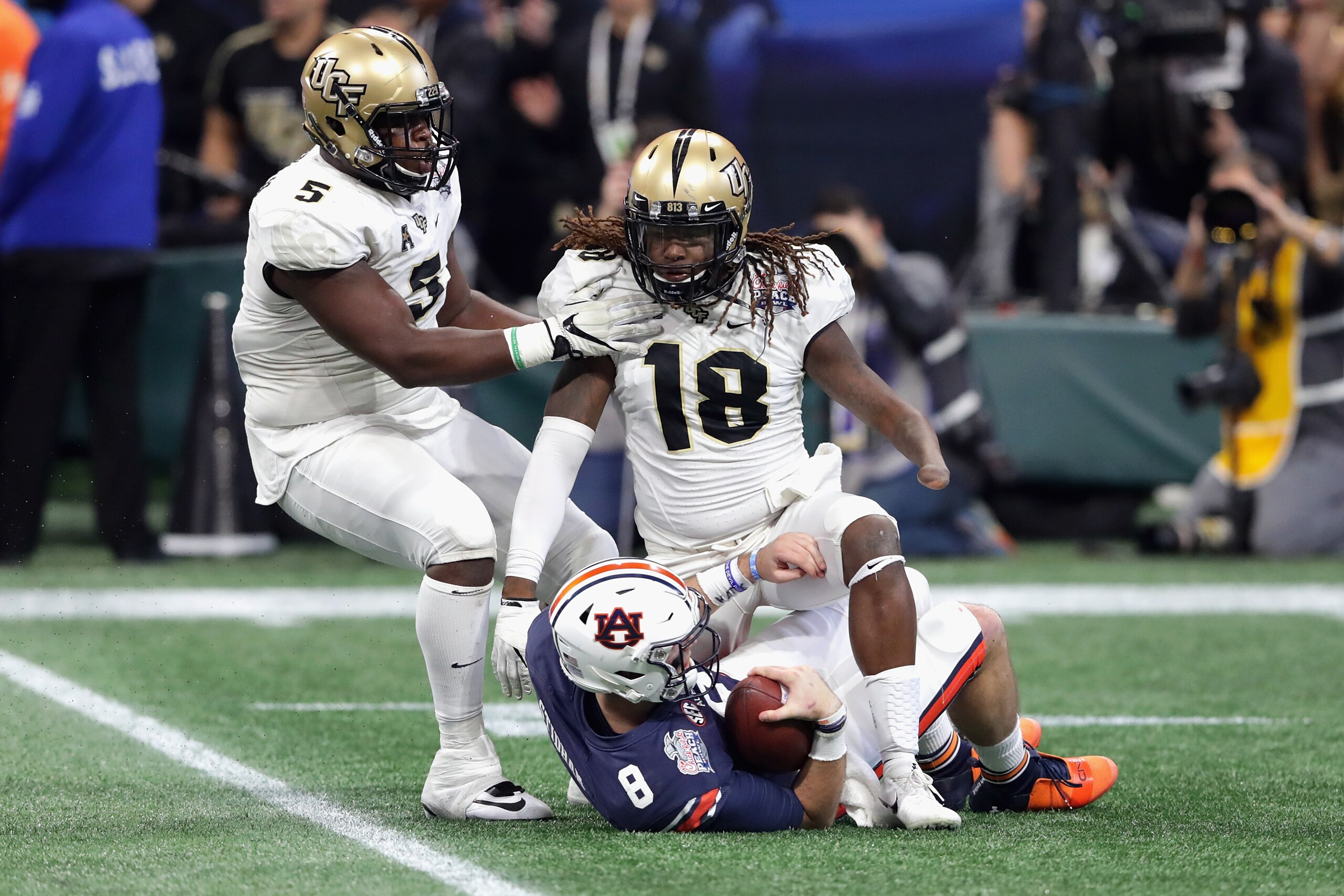 ATLANTA, GA - JANUARY 01:  Shaquem Griffin #18 of the UCF Knights steps over Jarrett Stidham #8 of the Auburn Tigers after making a sack in the second quarter during the Chick-fil-A Peach Bowl at Mercedes-Benz Stadium on January 1, 2018 in Atlanta, Georgi