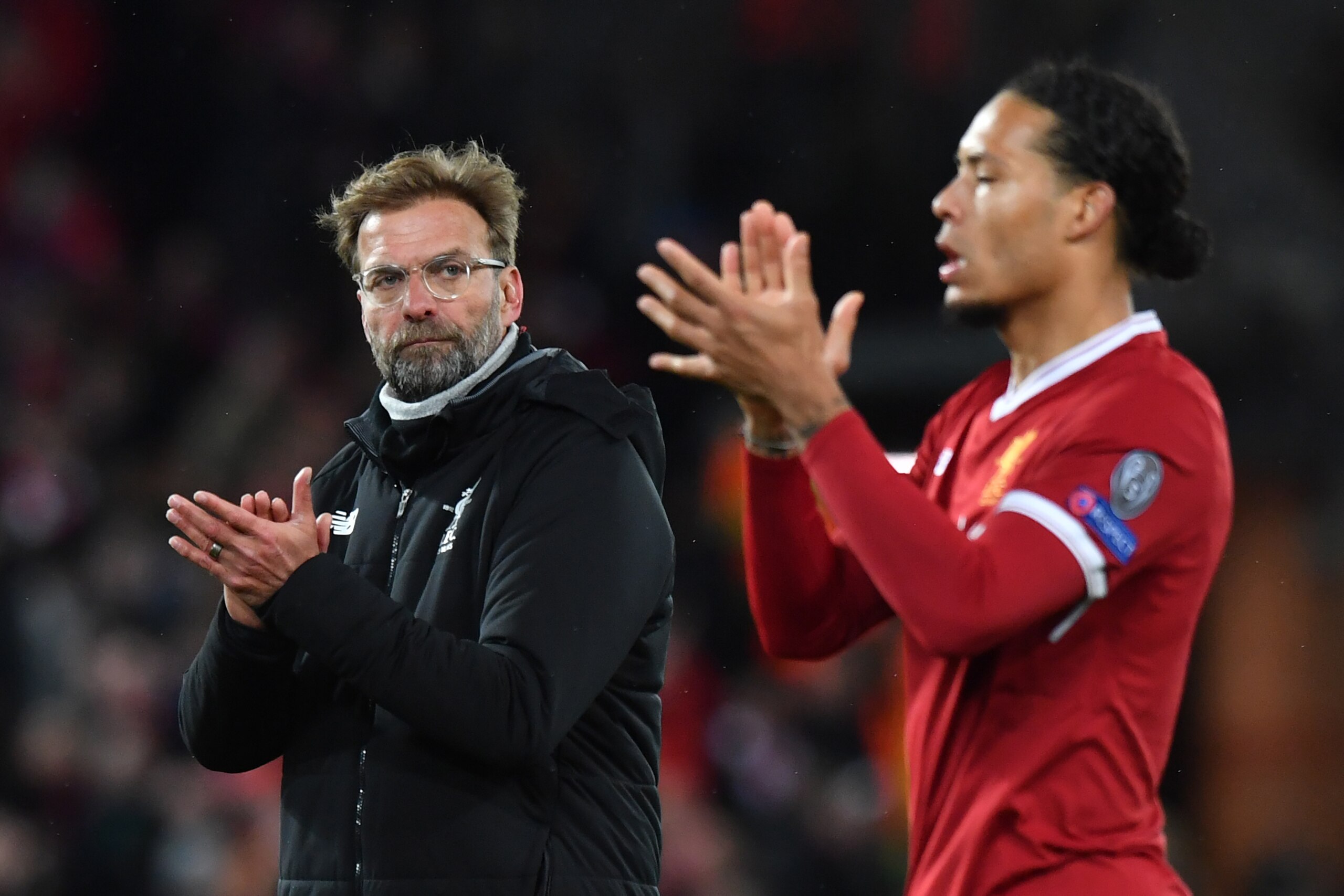 Liverpool's German manager Jurgen Klopp (L) and Liverpool's Dutch defender Virgil van Dijk react at the final whistle during the UEFA Champions League first leg quarter-final football match between Liverpool and Manchester City, at Anfield stadium in Live