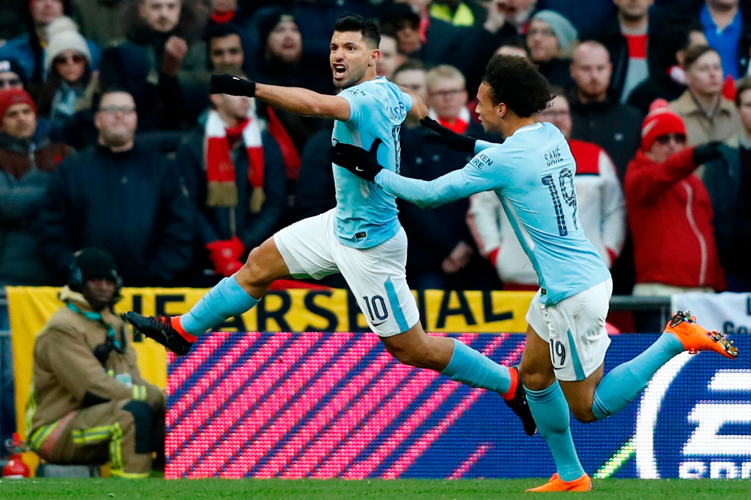 Manchester City's Argentinian striker Sergio Aguero celebrates with Manchester City's German midfielder Leroy Sane (R) after scoring the opening goal during the English League Cup final football match between Manchester City and Arsenal at Wembley stadium