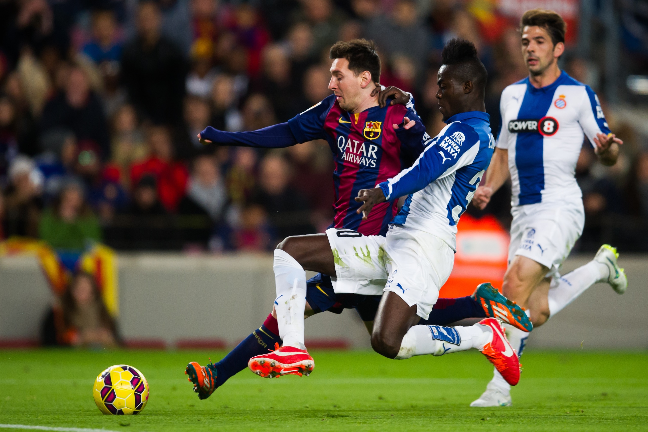 BARCELONA, SPAIN - DECEMBER 07: Lionel Messi (C) of FC Barcelona fights for the ball with Eric Bailly of RCD Espanyol during the La Liga match between FC Barcelona and RCD Espanyol at Camp Nou on December 7, 2014 in Barcelona, Spain. (Photo by Alex Caparr