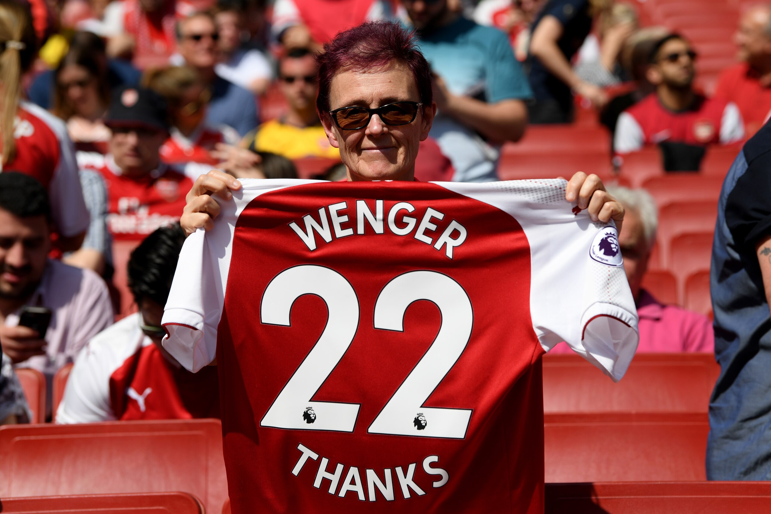 LONDON, ENGLAND - APRIL 22: A fan poses with an Arsenal shirt, displaying text to thank Arsene Wenger, Manager of Arsenal during the Premier League match between Arsenal and West Ham United at Emirates Stadium on April 22, 2018 in London, England.  (Photo