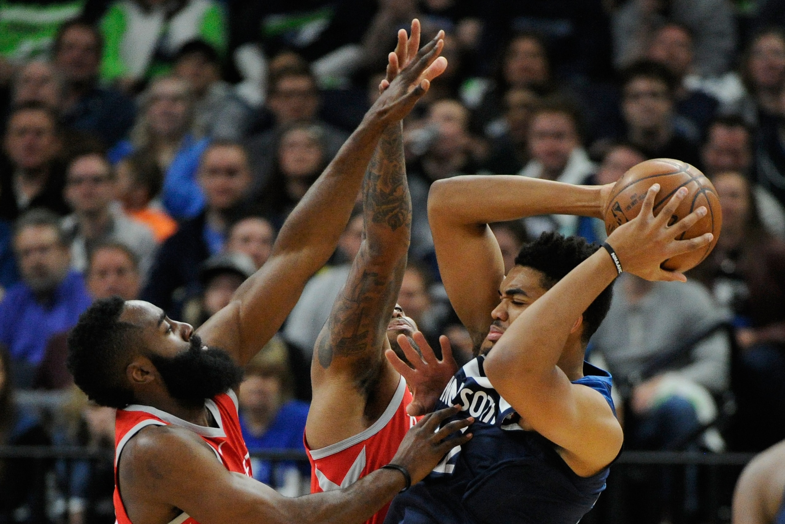 MINNEAPOLIS, MN - APRIL 21: James Harden #13 and PJ Tucker #4 of the Houston Rockets defend against Karl-Anthony Towns #32 of the Minnesota Timberwolves during the first quarter in Game Three of Round One of the 2018 NBA Playoffs on April 21, 2018 at the 