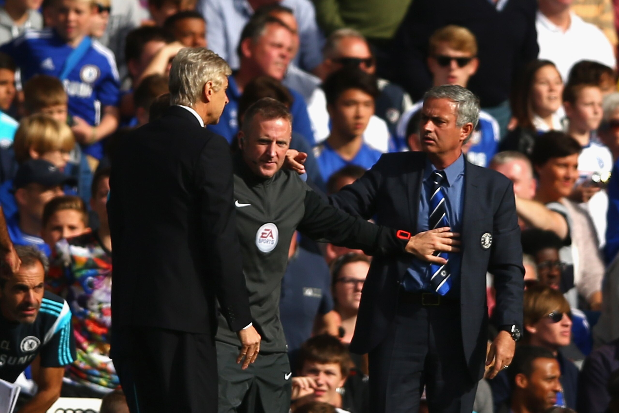 LONDON, ENGLAND - OCTOBER 05:  Fourth Official Jonathan Moss comes between Managers Arsene Wenger of Arsenal and Jose Mourinho manager of Chelsea during the Barclays Premier League match between Chelsea and Arsenal at Stamford Bridge on October 4, 2014 in