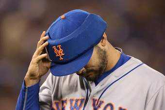 TORONTO, CANADA - JUNE 18: Alex Torres #54 of the New York Mets reaches for his protective cap as he walks off the mound at the end of the fifth inning during MLB game action against the Toronto Blue Jays on June 18, 2015 at Rogers Centre in Toronto, Onta
