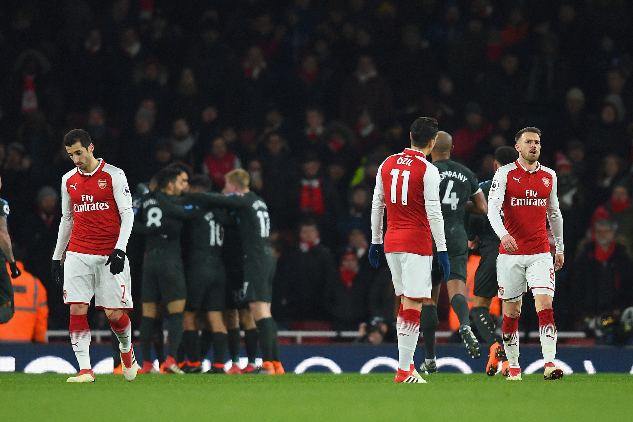 LONDON, ENGLAND - MARCH 01: Henrikh Mkhitaryan, Mesut Ozil and Aaron Ramsey of Arsenal are dejected after the 2nd Man City goal during the Premier League match between Arsenal and Manchester City at Emirates Stadium on March 1, 2018 in London, England.  (