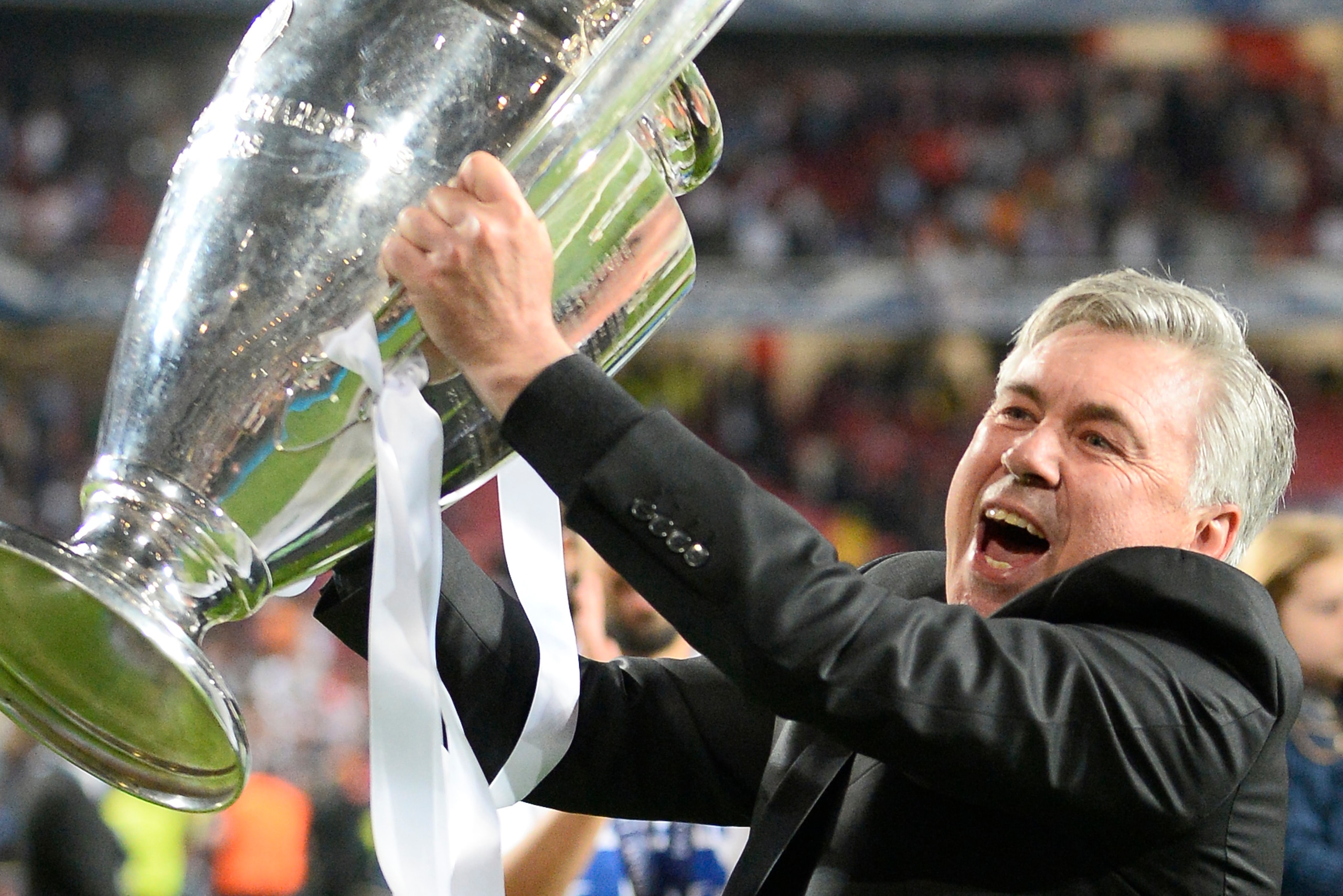 Real Madrid's Italian coach Carlo Ancelotti celebrates with the trophy at the end of the UEFA Champions League Final Real Madrid vs Atletico de Madrid at Luz stadium in Lisbon, on May 24, 2014. Real Madrid won 4-1.  AFP PHOTO/ MIGUEL RIOPA / AFP PHOTO / M