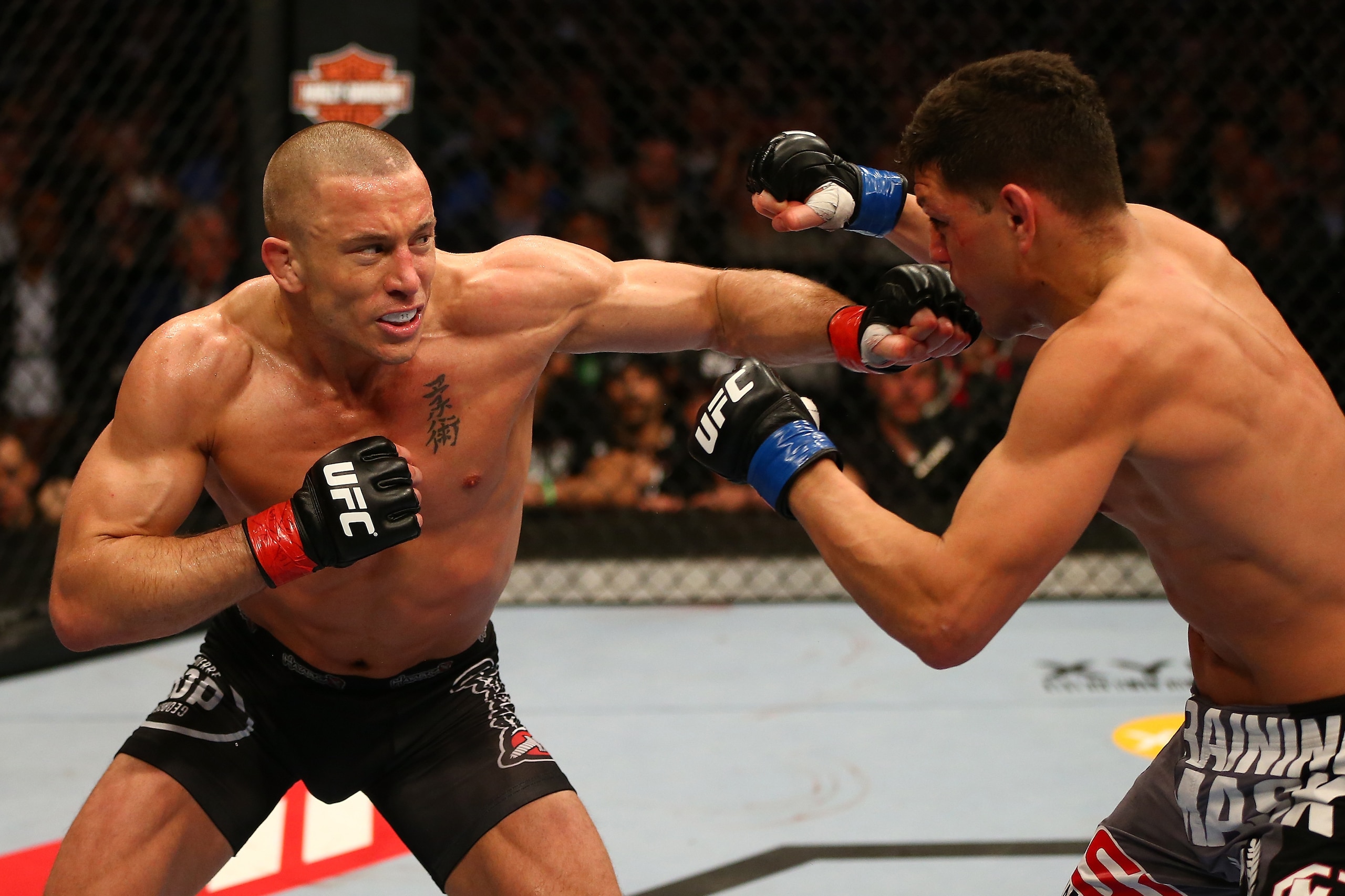 MONTREAL, QC - MARCH 16:  (L-R) Georges St-Pierre punches Nick Diaz in their welterweight championship bout during the UFC 158 event at Bell Centre on March 16, 2013 in Montreal, Quebec, Canada.  (Photo by Jonathan Ferrey/Zuffa LLC/Zuffa LLC via Getty Ima