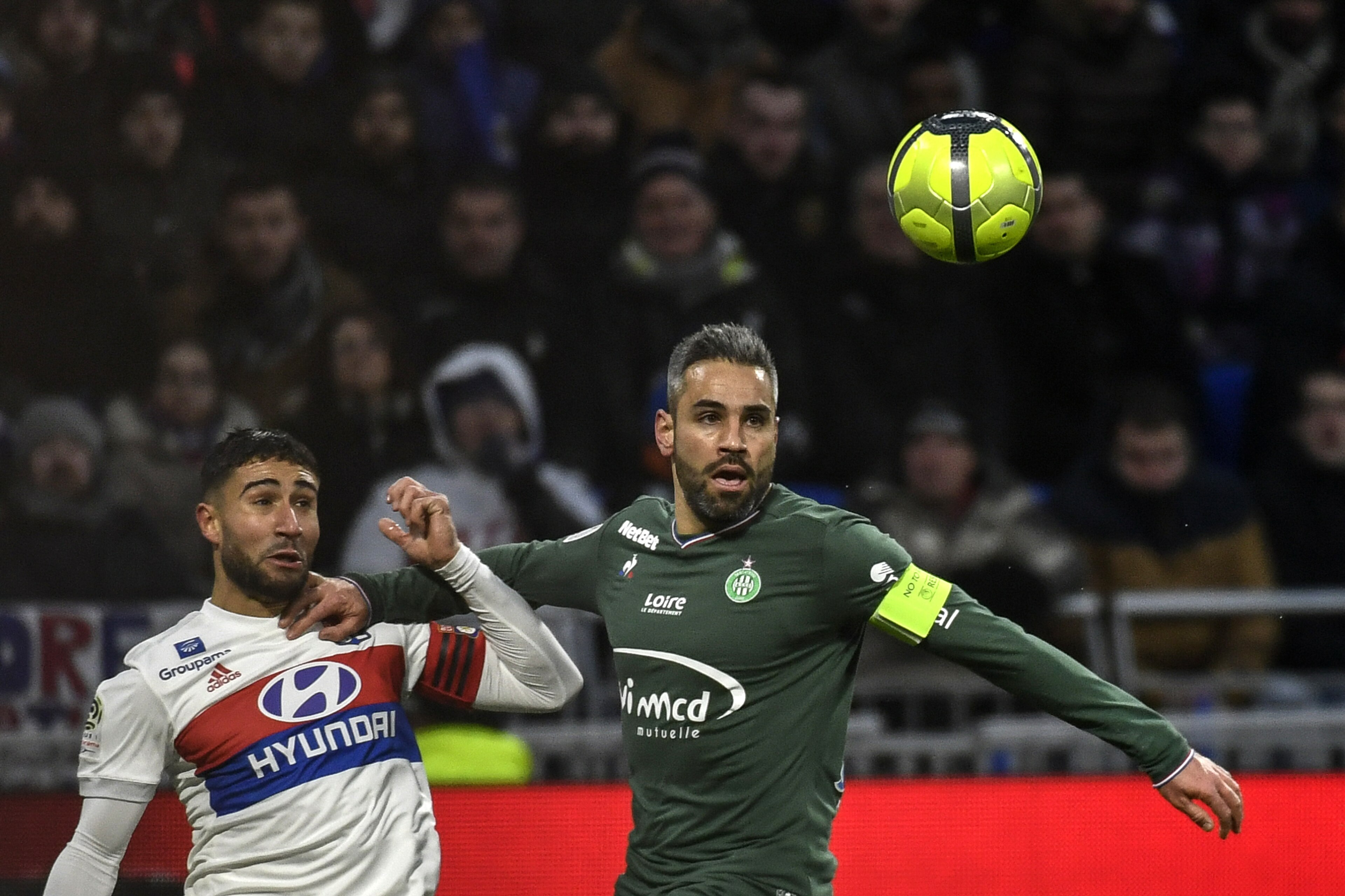 Saint-Etienne's French defender Loic Perrin (R) vies with Lyon's French midfielder Nabil Fekir during the French L1 football match Olympique Lyonnais (OL) versus AS Saint-Etienne (ASSE) on February 25, 2018 at the Groupama Stadium in Decines-Charpieu, nea
