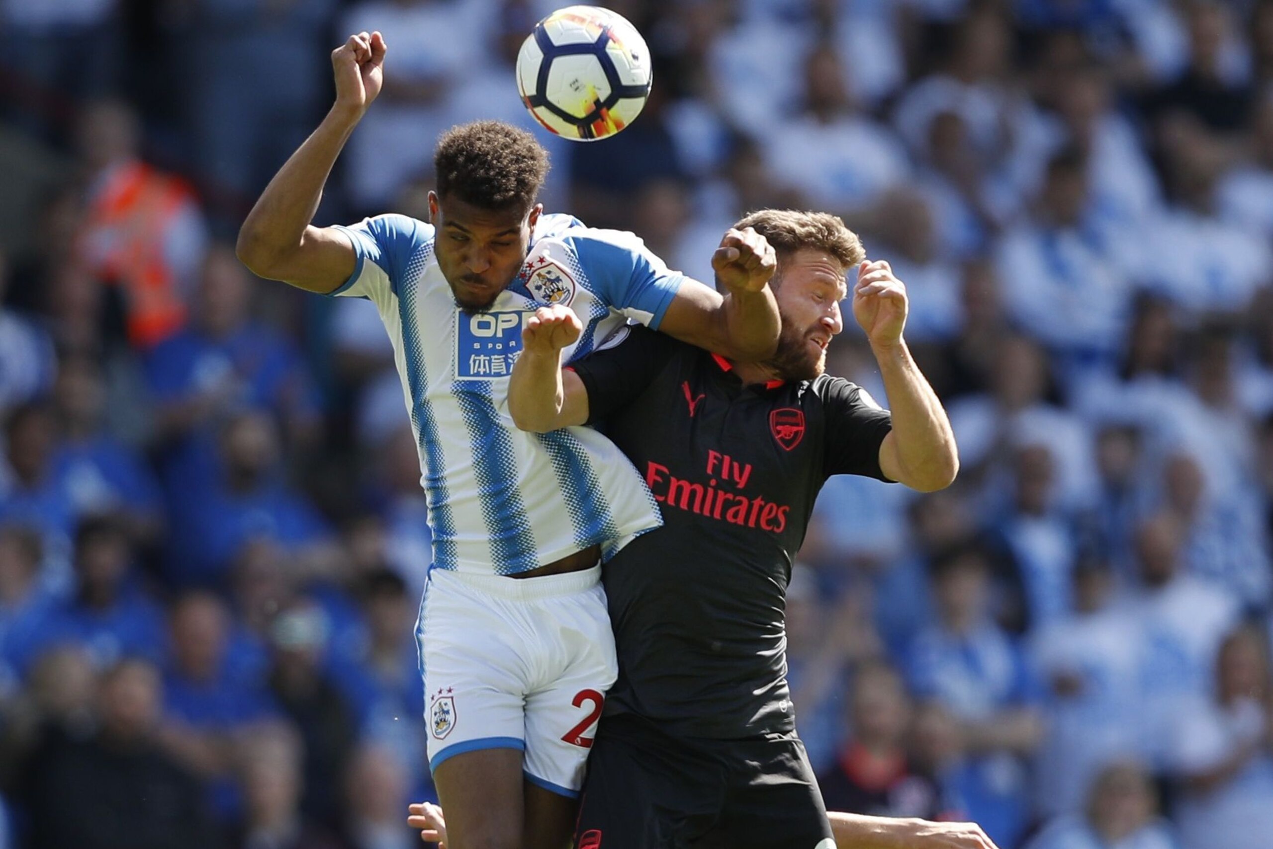 Huddersfield Town's Beninese striker Steve Mounie (L) jumps for a header with Arsenal's German defender Shkodran Mustafi during the English Premier League football match between Huddersfield Town and Arsenal at the John Smith's stadium in Huddersfield, no