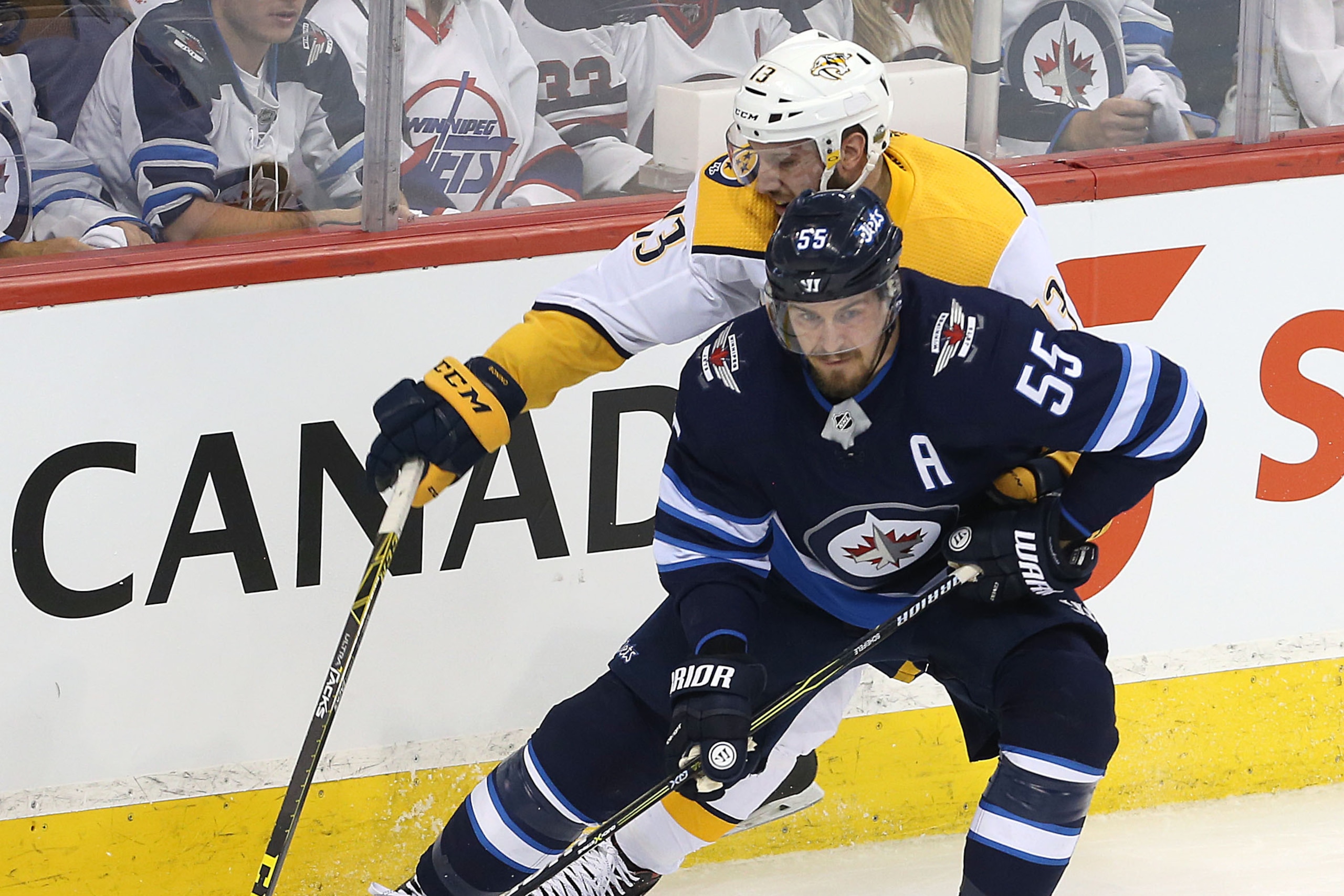 WINNIPEG, MANITOBA - MAY 3: Mark Scheifele #55 of the Winnipeg Jets works the puck past Nick Bonino #13 of the Nashville Predators in Game Four of the Western Conference Second Round during the 2018 NHL Stanley Cup Playoffs on May 3, 2018 at Bell MTS Plac WINNIPEG, MANITOBA - MAY 3: Mark Scheifele #55 of the Winnipeg Jets works the puck past Nick Bonino #13 of the Nashville Predators in Game Four of the Western Conference Second Round during the 2018 NHL Stanley Cup Playoffs on May 3, 2018 at Bell MTS Plac