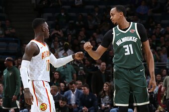 MILWAUKEE, WI - MARCH 17: Dennis Schroder #17 of the Atlanta Hawks and John Henson #31 of the Milwaukee Bucks high five before the game on March 17, 2018 at the BMO Harris Bradley Center in Milwaukee, Wisconsin. NOTE TO USER: User expressly acknowledges a