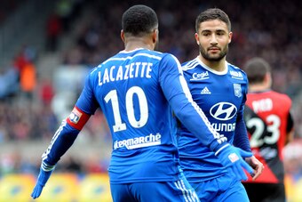 Lyon's French midfielder Nabil Fekir (C) is congratulated by Lyon's French forward Alexandre Lacazette (L) after scoring a goal during the French L1 football match between Guingamp and Lyon on April 4, 2015 at the Roudourou stadium in Guingamp, western of